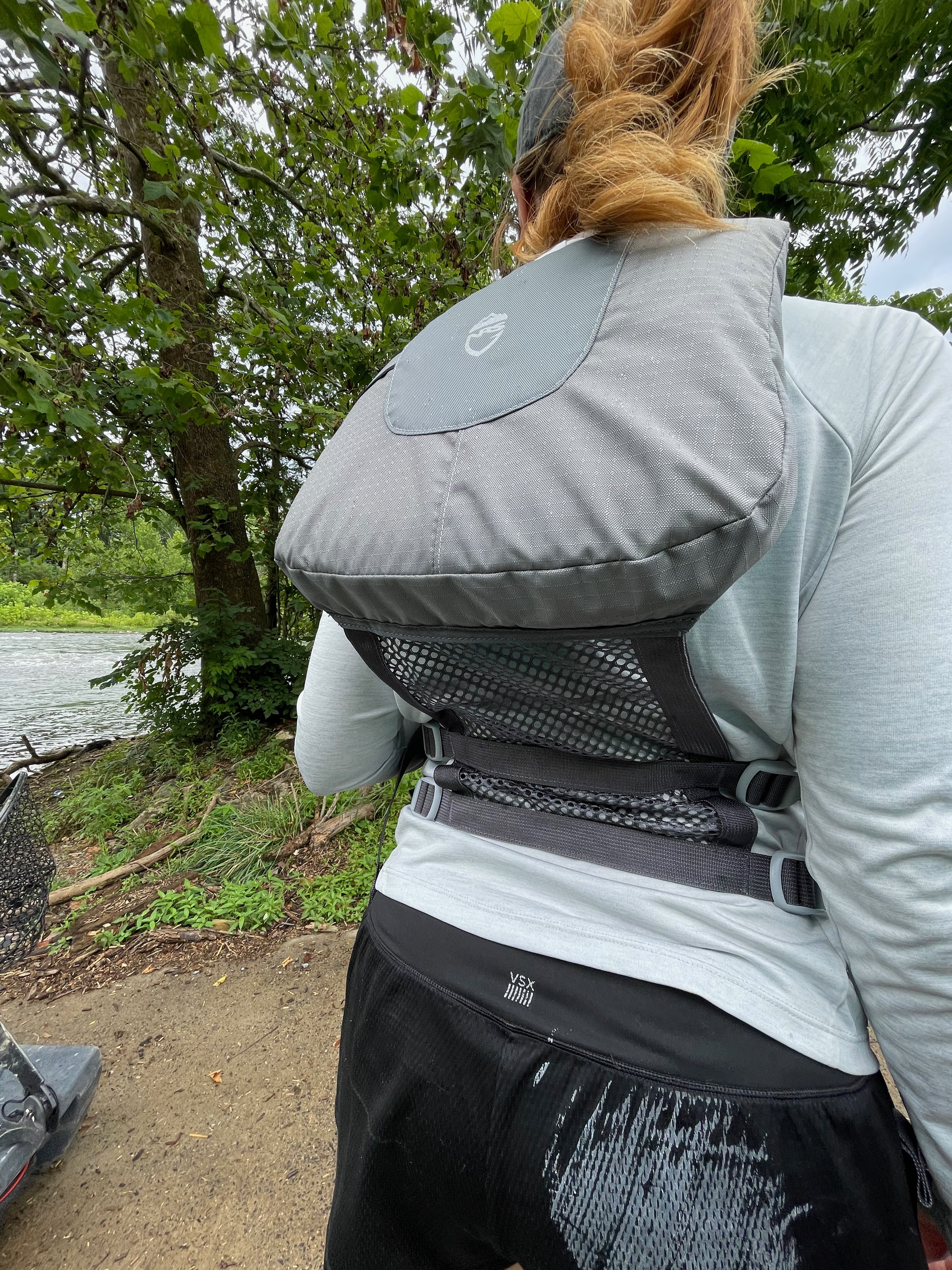 A green NRS Chinook fishing life jacket featuring multiple front storage pockets and attachment loops.