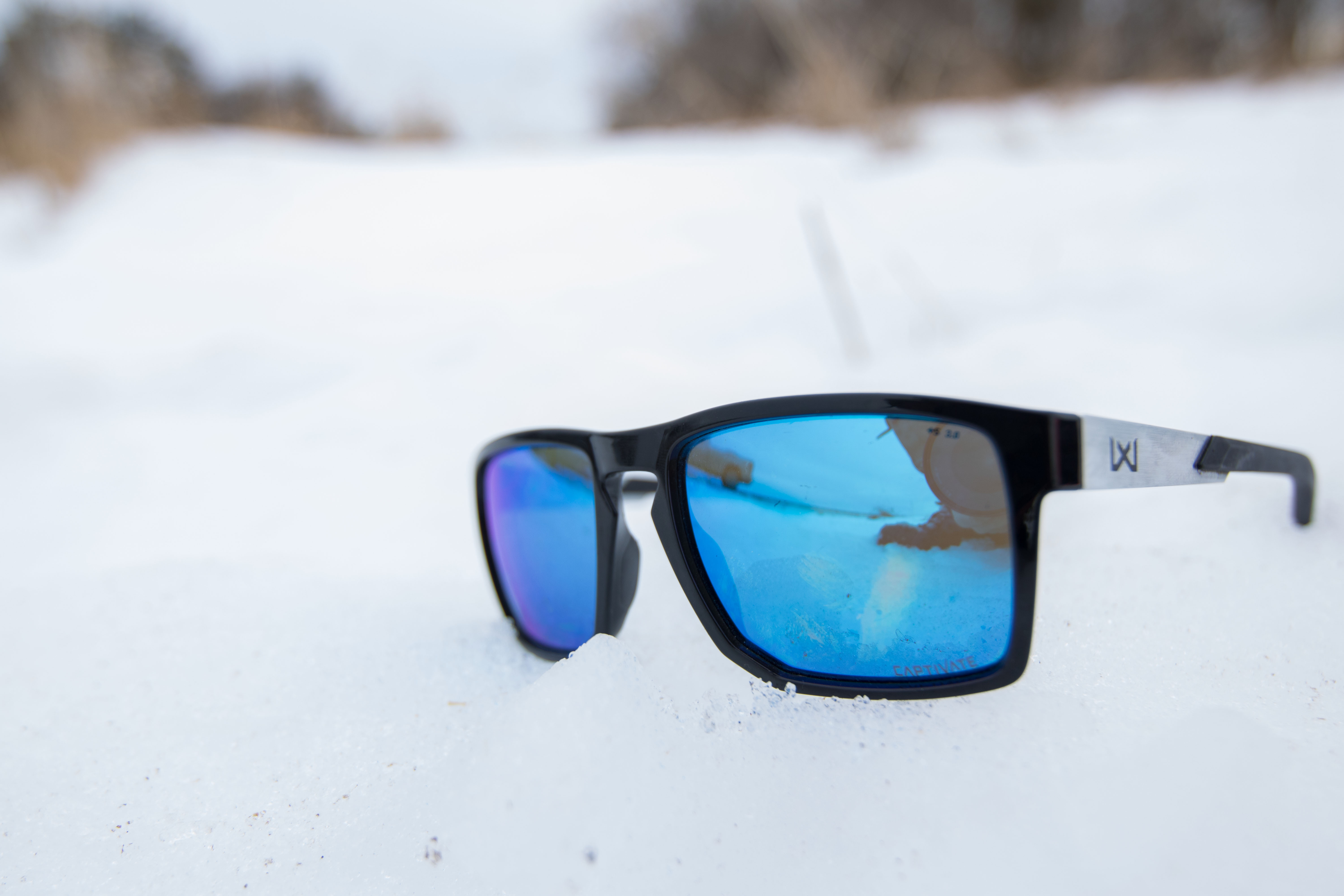 A pair of Wiley X Apex sunglasses resting on a field of white snow.
