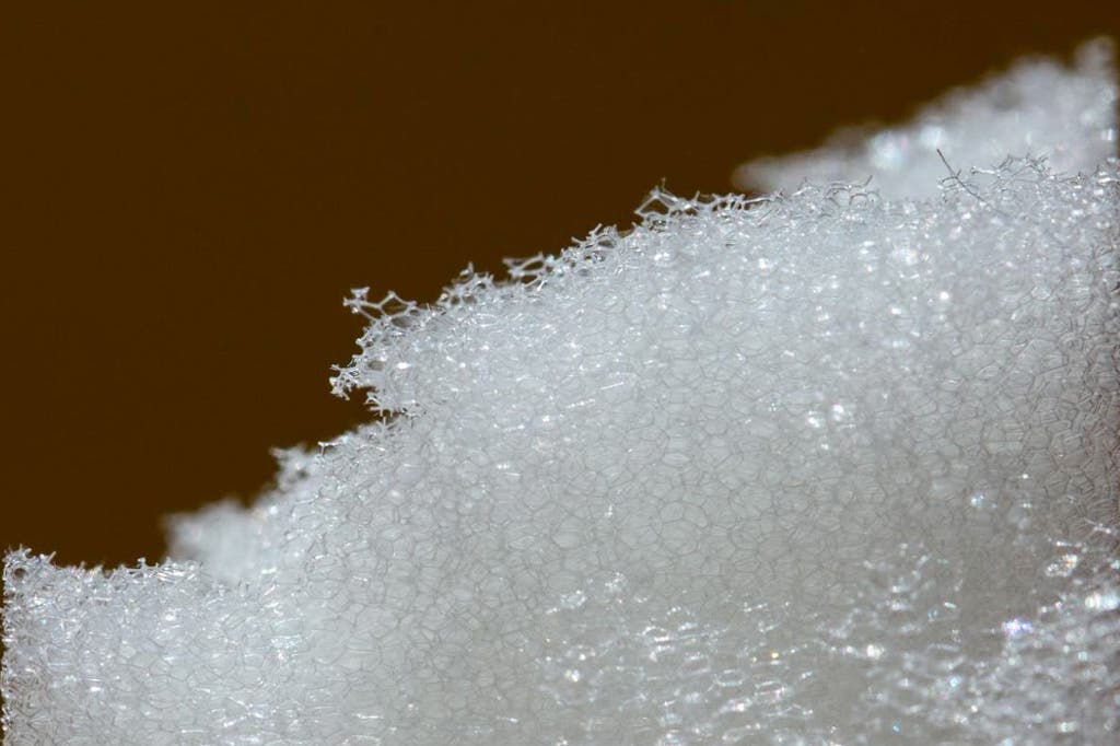 Macro close-up shot showing the porous structure of open-cell insulation foam