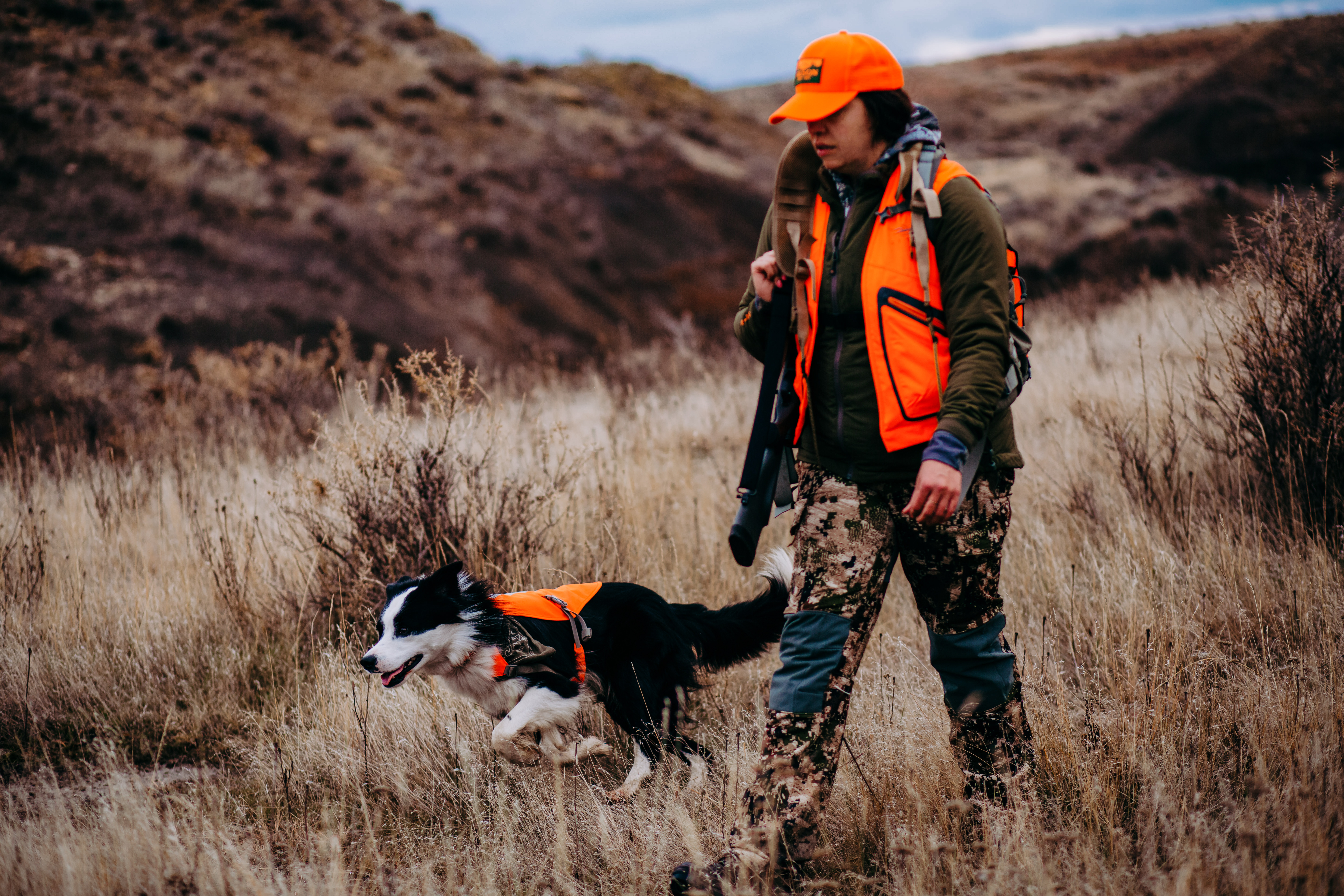A woman hunter and her dog relaxing at a hunting camp.