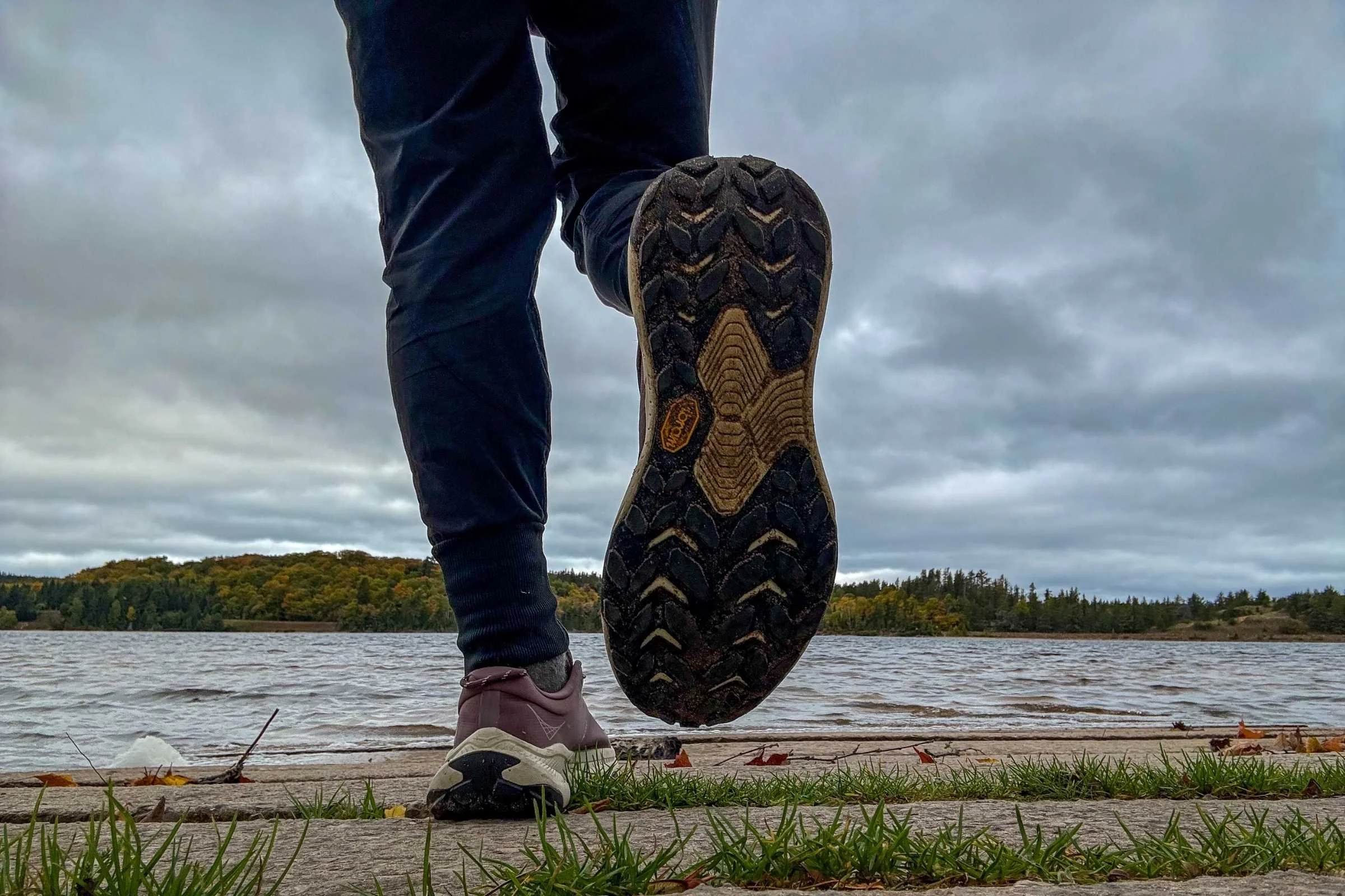Detailed view of the lug pattern and Vibram logo on the sole of a HOKA Transport 2 shoe.