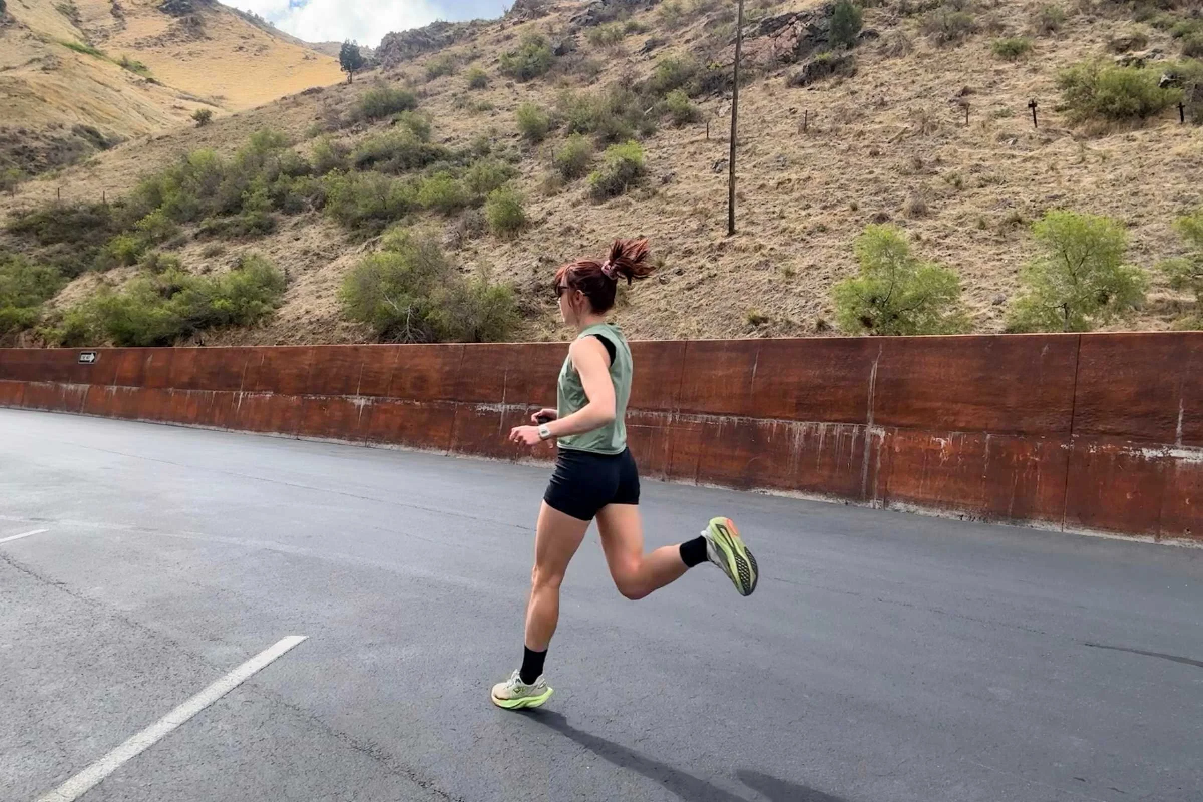 A runner wearing HOKA Mach 7 during an outdoor training session on a paved path.