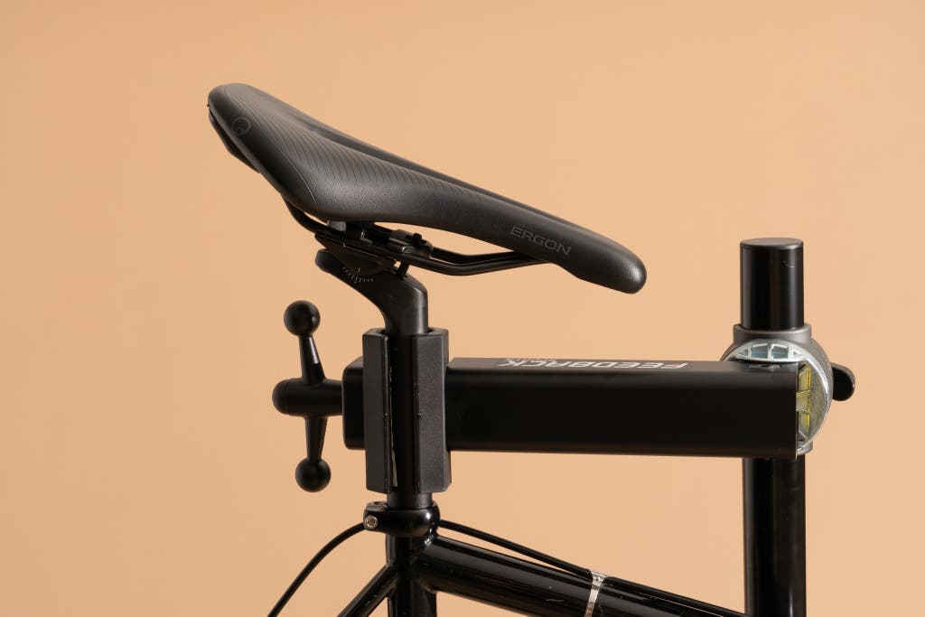 Close-up of a repair stand clamp secured around a bicycle seatpost.