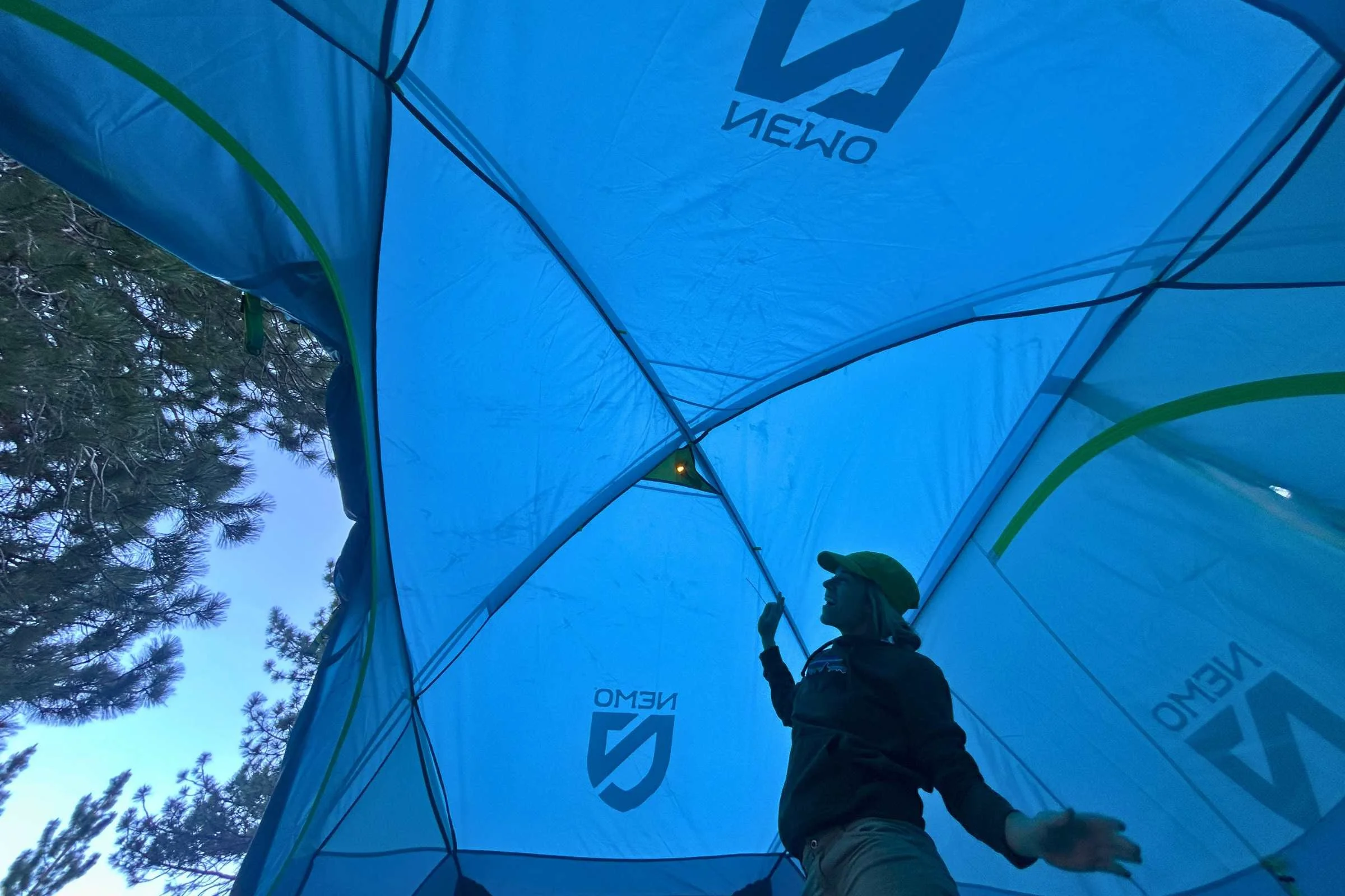 Interior shot looking up at the high ceiling and vertical walls of a tall camping tent.