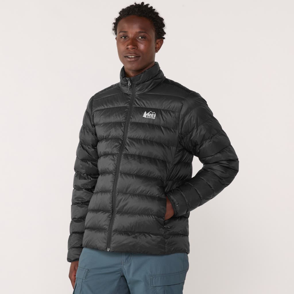 A man wearing a blue REI Co-op down jacket outdoors.