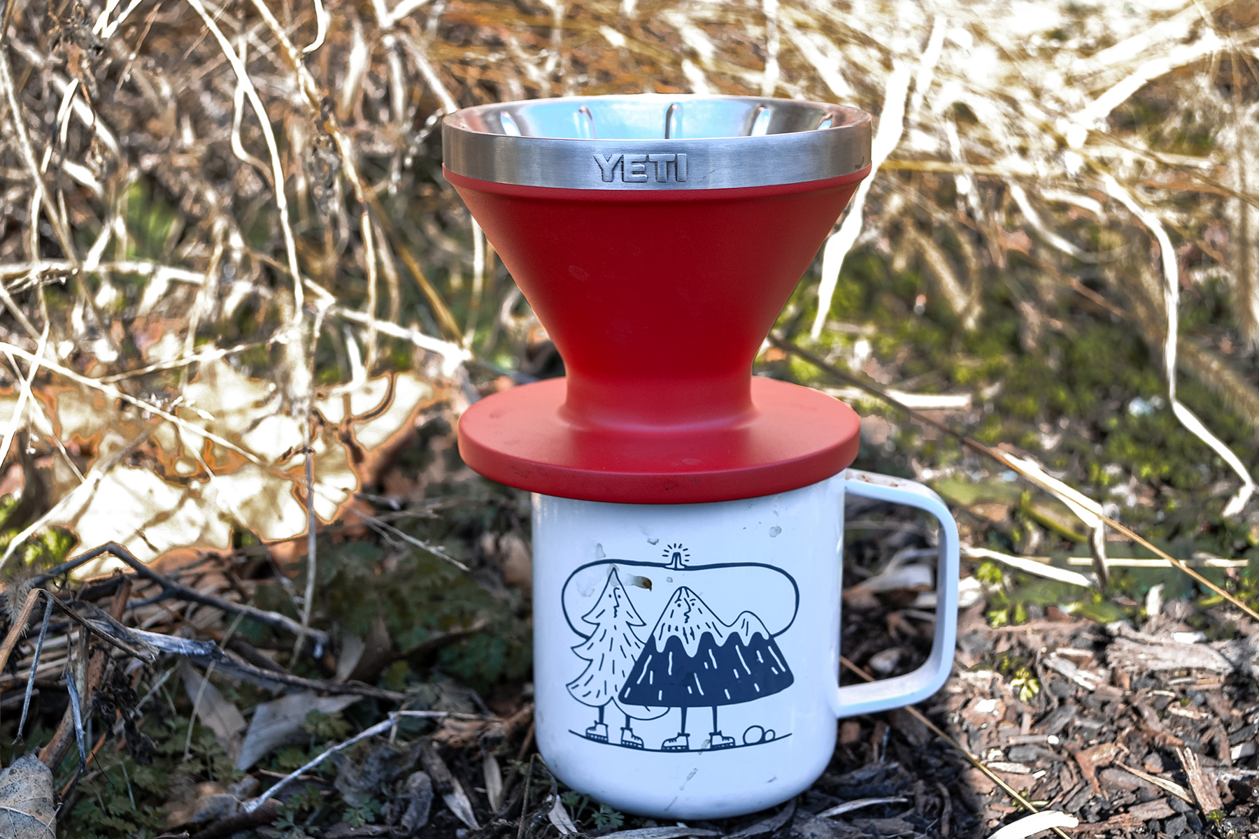 A YETI brand pour-over coffee dripper sitting on top of a stainless steel camp mug.