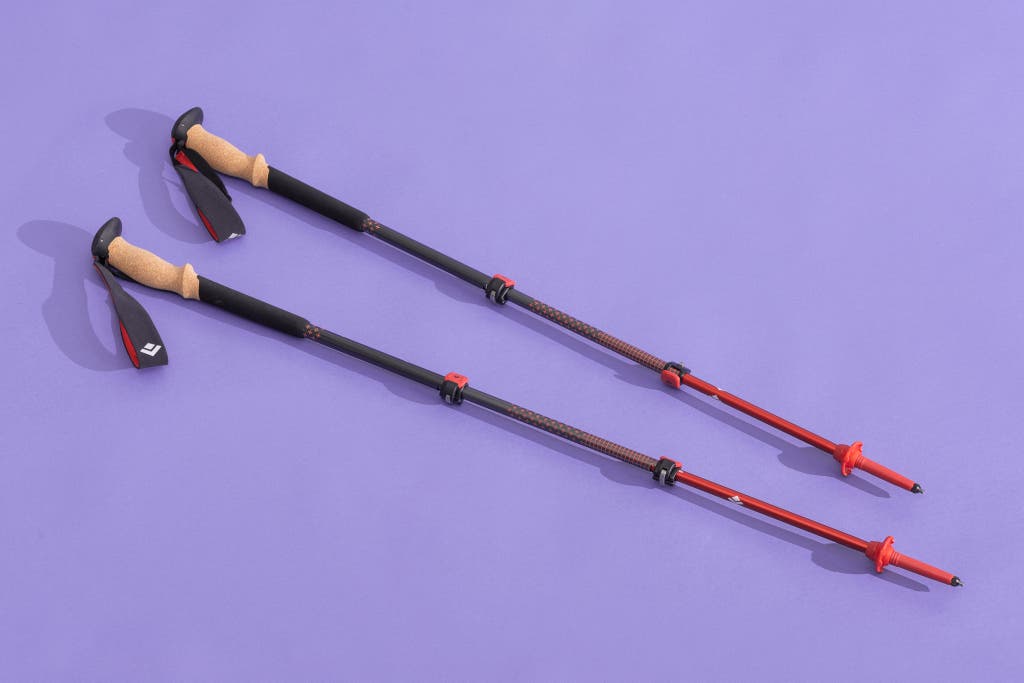 A pair of Black Diamond Pursuit trekking poles featured against a solid purple background.