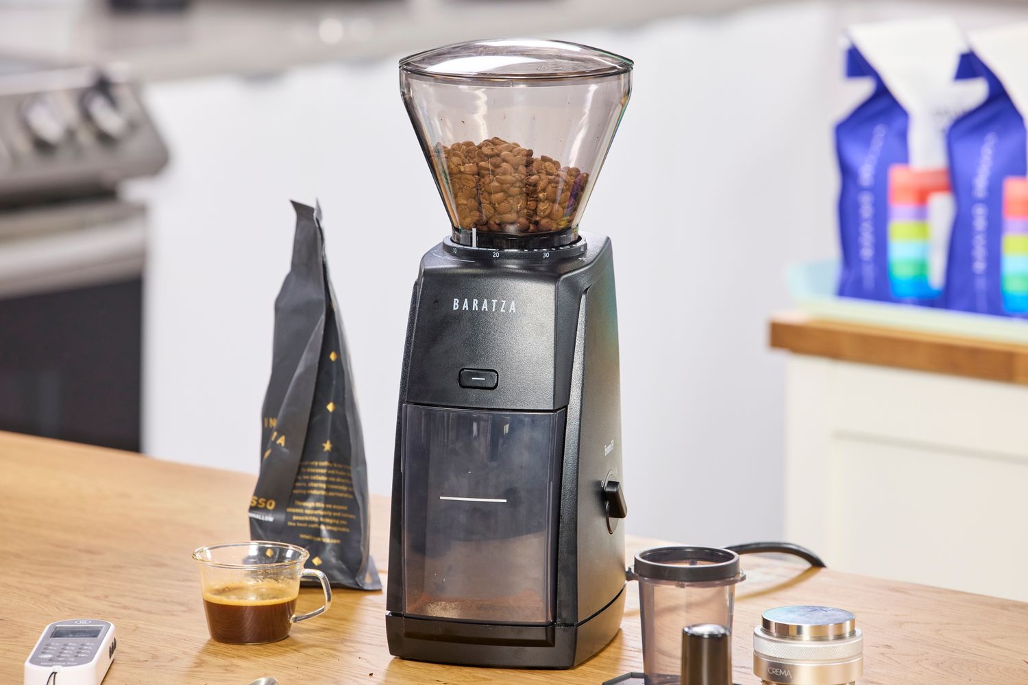 A close-up view of roasted coffee beans inside the hopper of a manual grinder.