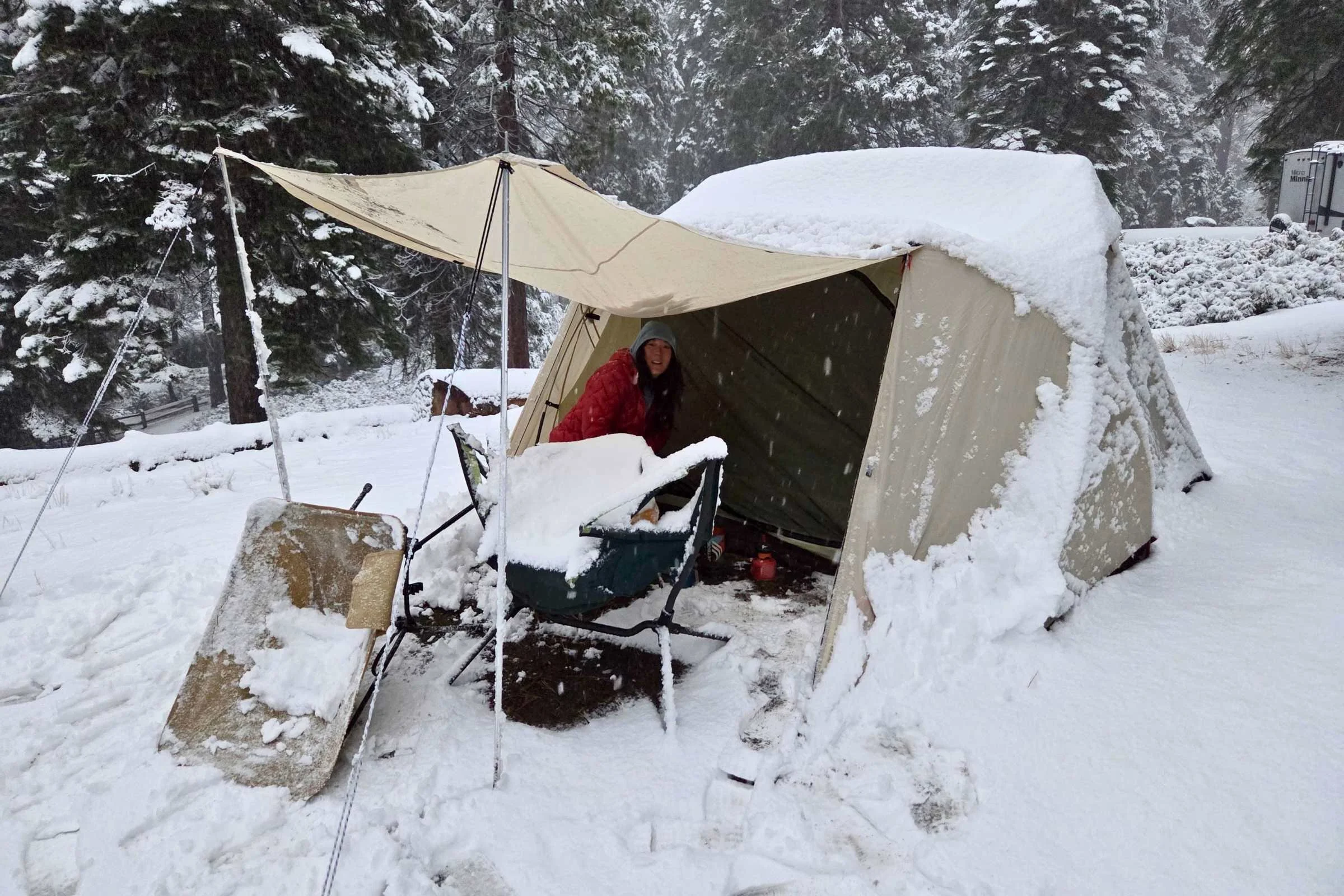 A large camping tent standing firm during a heavy snowstorm to show weather resistance.
