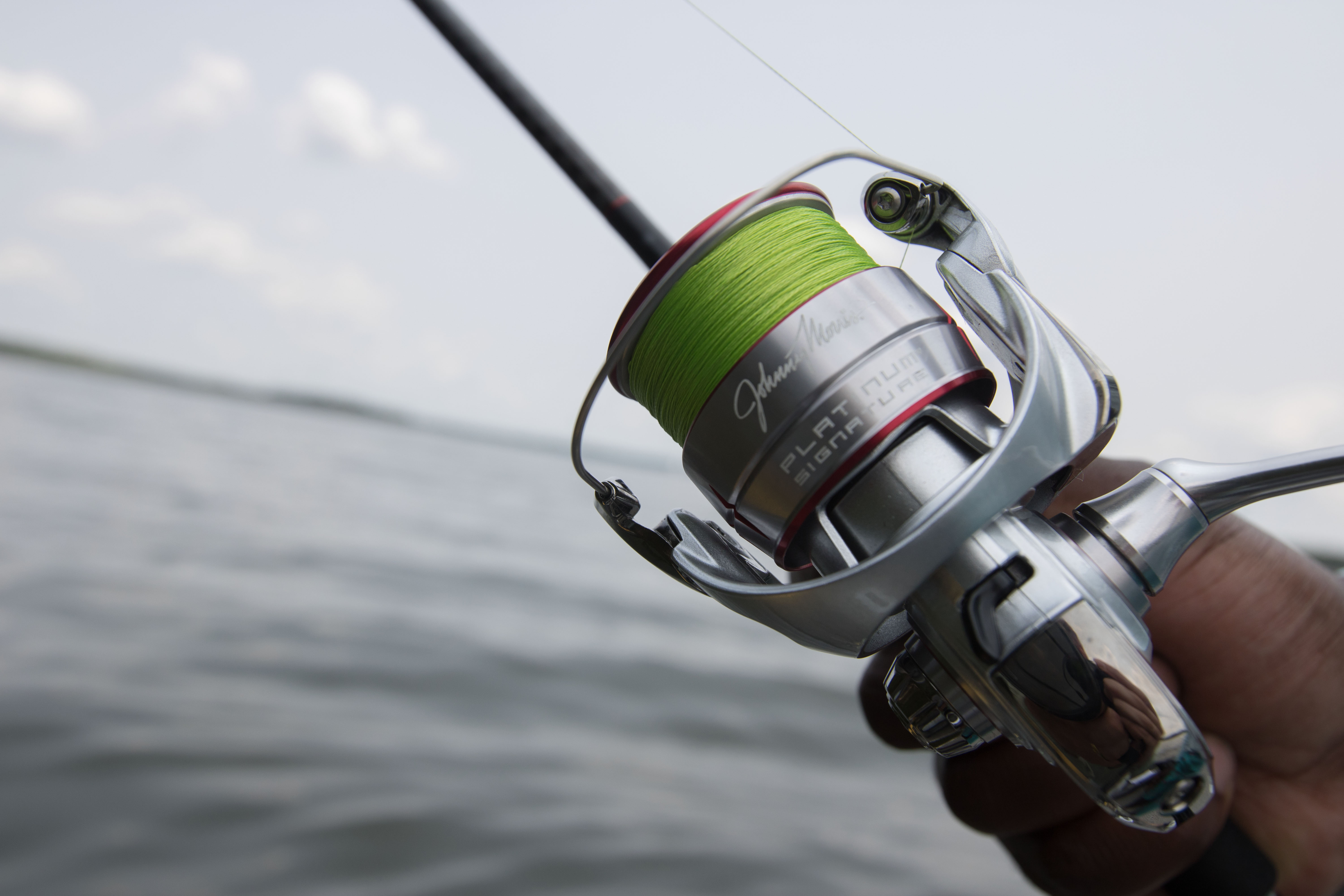 Close-up of the Johnny Morris Platinum Signature spinning reel mounted on a fishing rod.