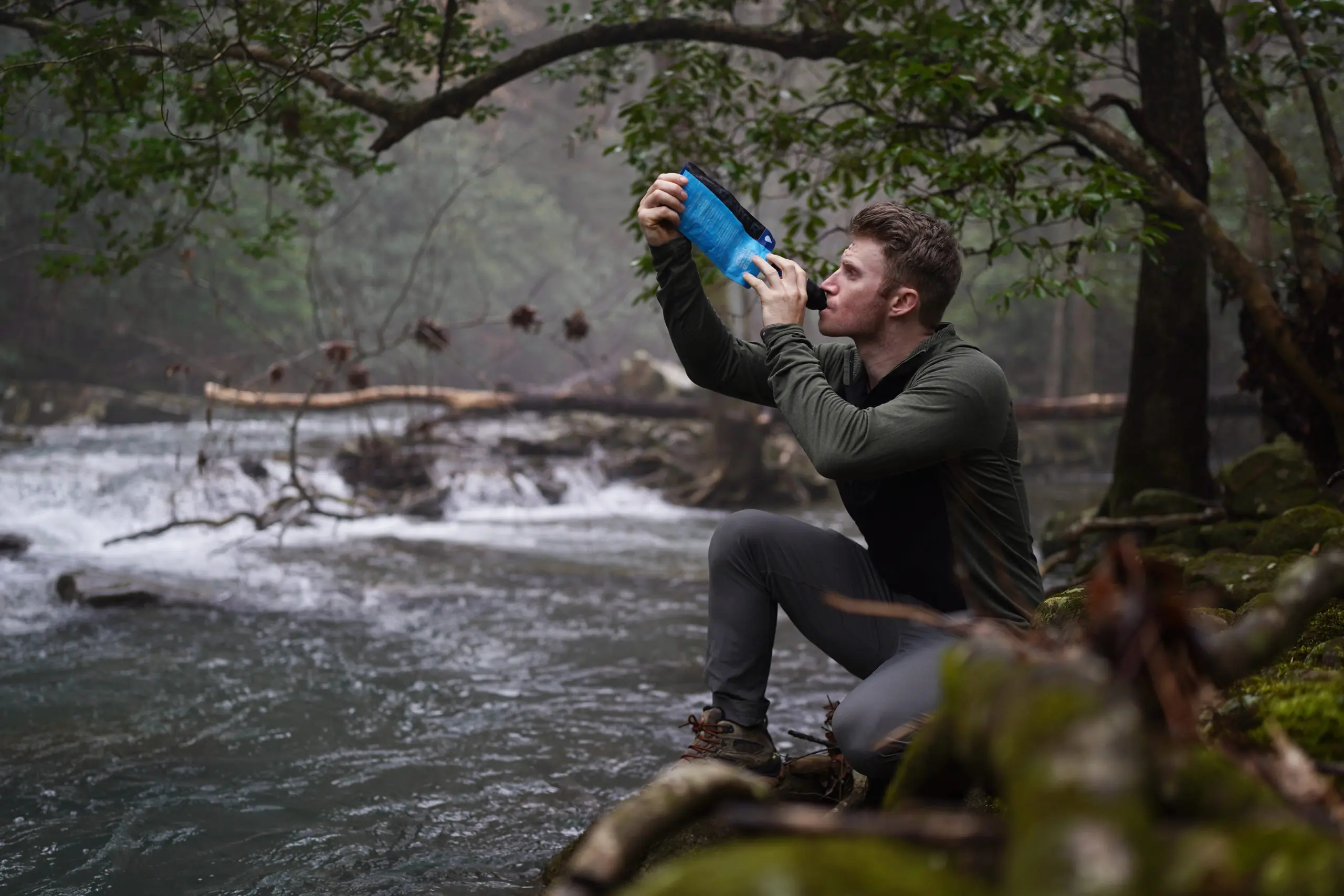 A traveler using a water purification device in a rural village setting