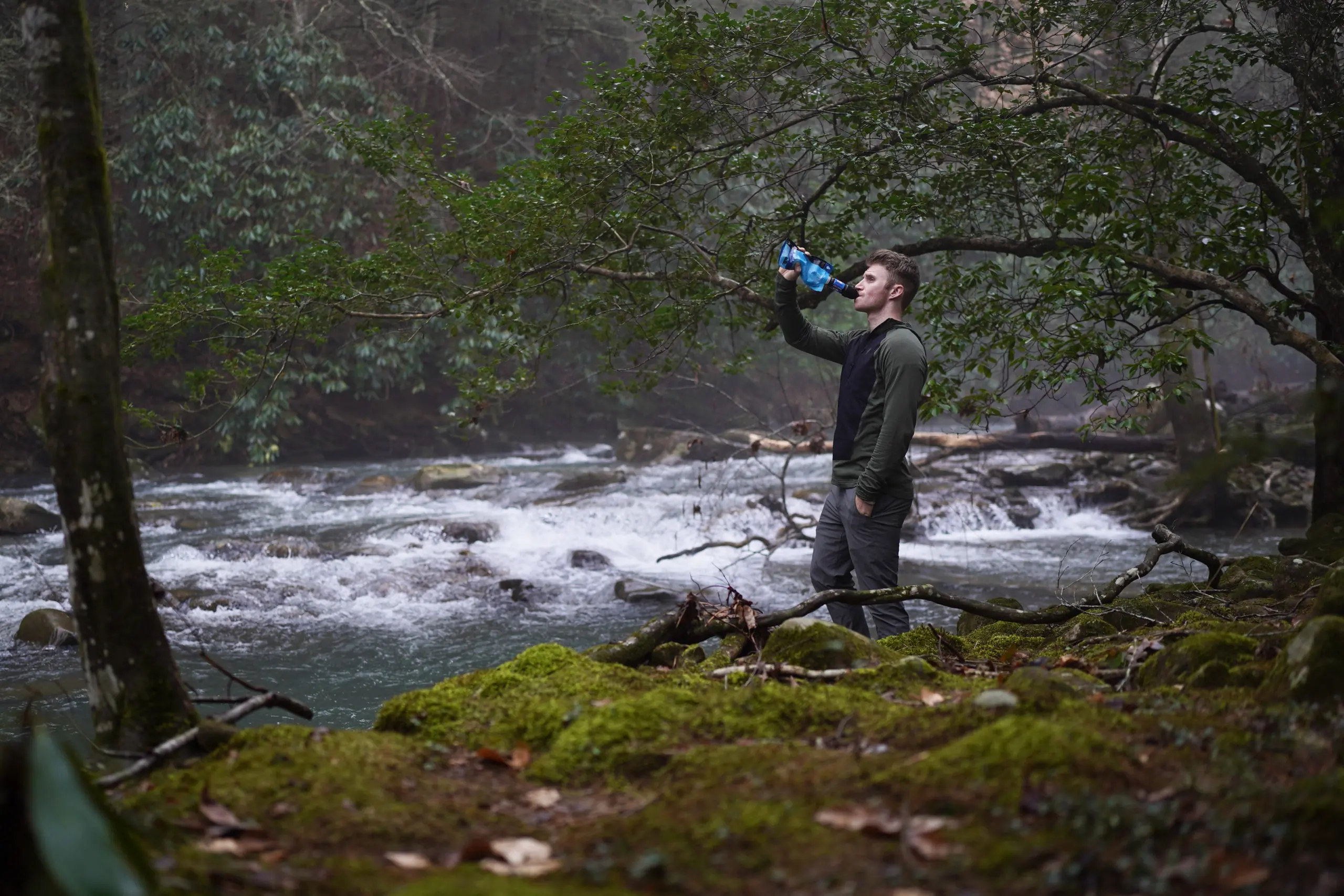 A small, lightweight water filter tucked into the side pocket of a backpacking pack