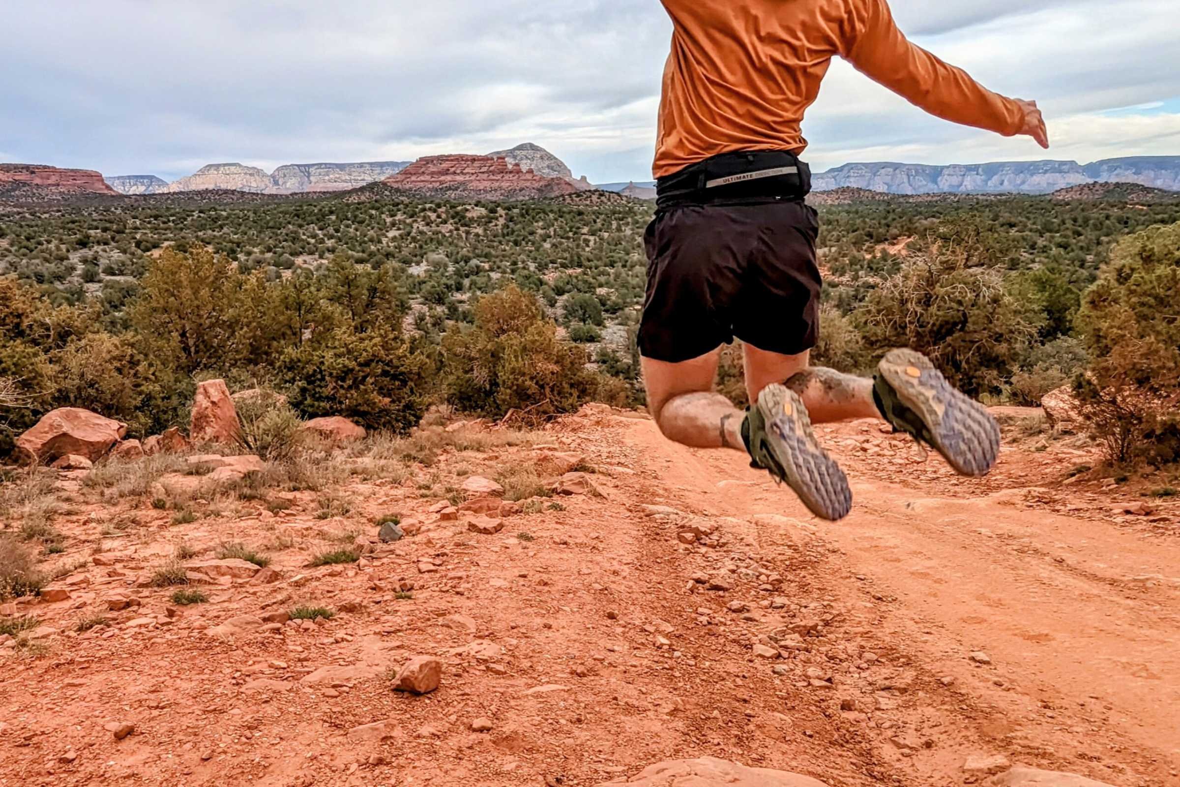 A runner testing a belt in a mountainous trail environment.