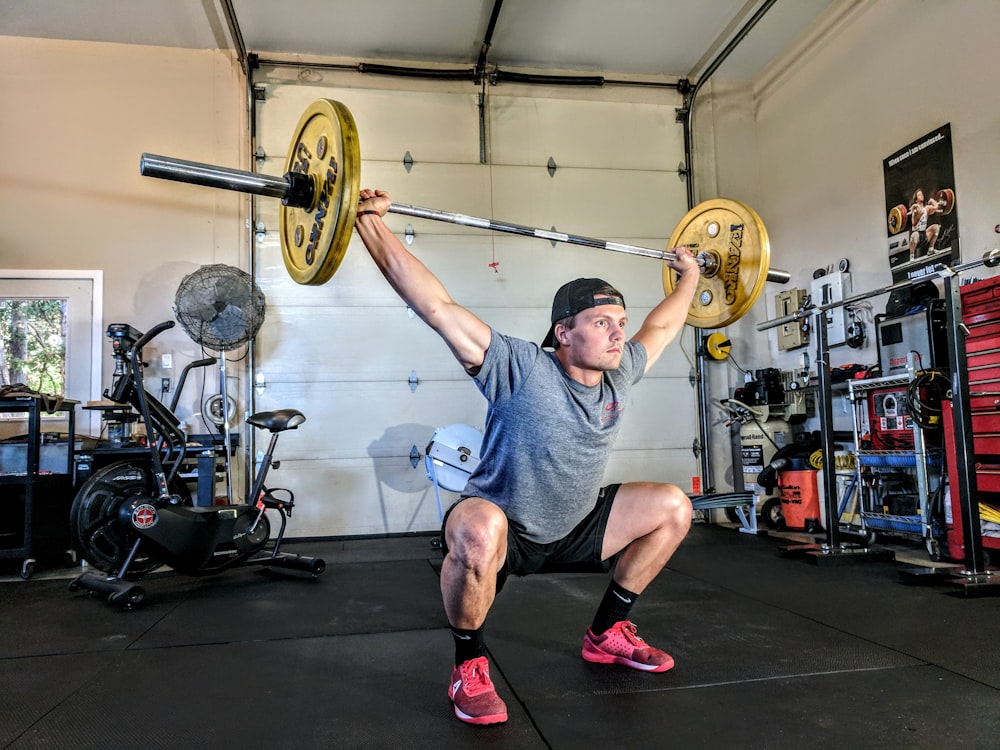An AeroPress coffee maker sitting on a wooden surface at a campsite with a mug nearby.