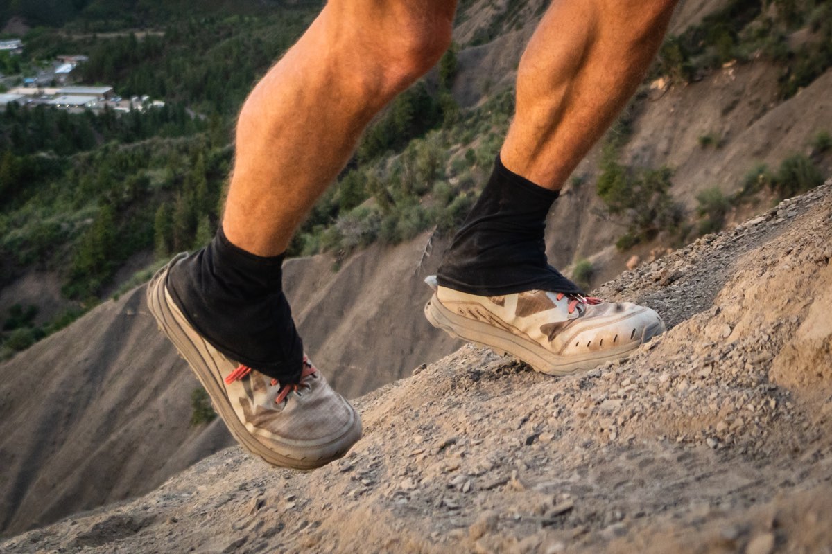Close-up shot of colorful patterned Dirty Girl Gaiters on trail running shoes.