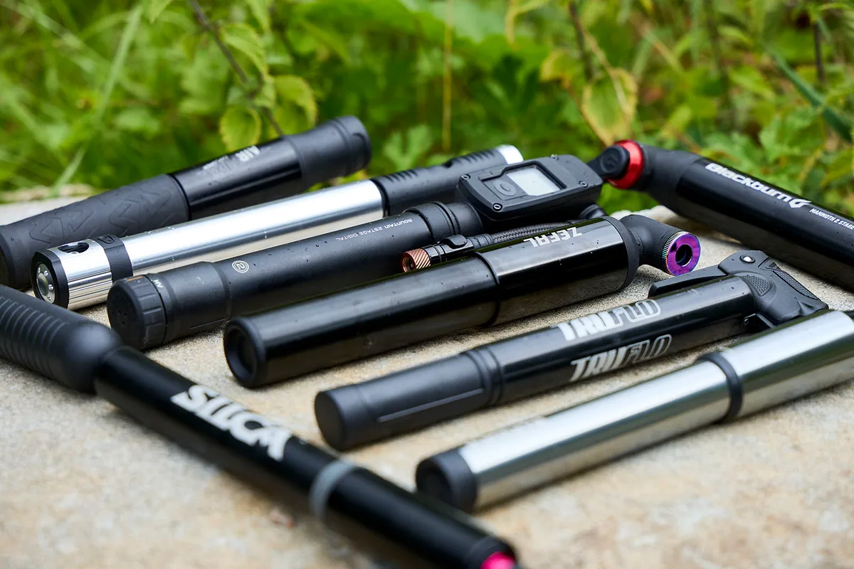 A collection of several compact handheld electric bicycle pumps of various shapes and sizes.