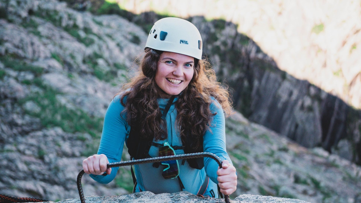 Tester Fliss Freeborn climbing a via ferrata in Corsica wearing technical hiking gear.