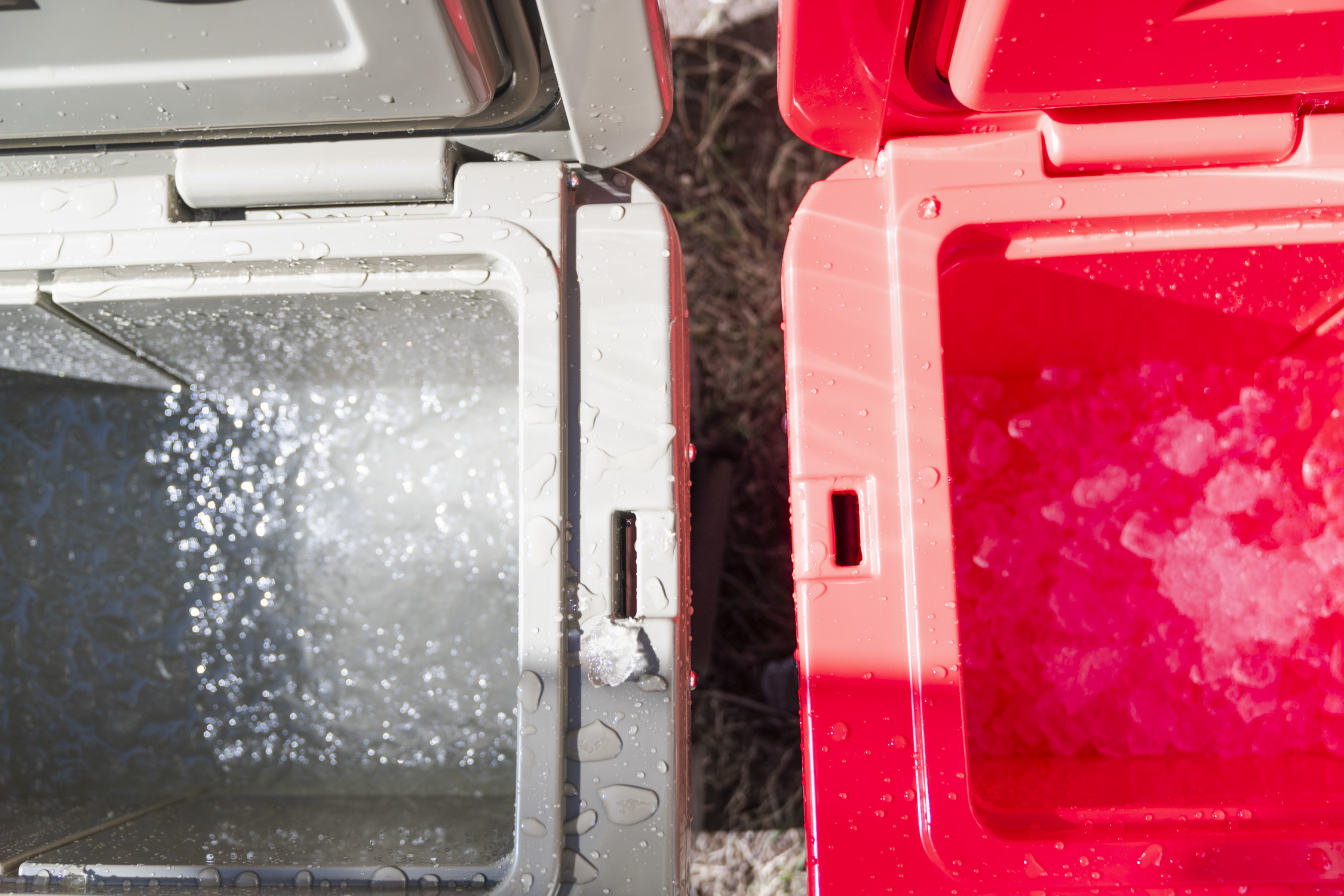 A long row of various coolers being tested for ice retention in a controlled outdoor environment.