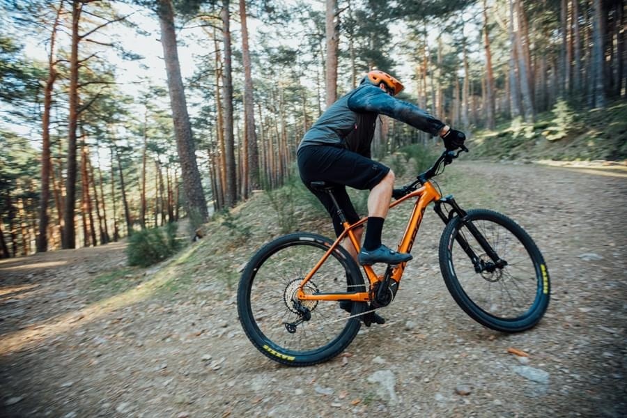 A mountain bike riding on a smooth, flowing dirt trail through a field.