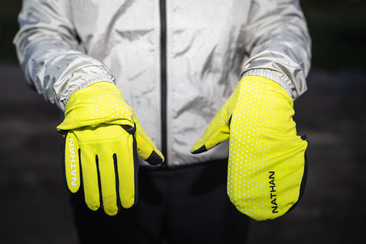 A close-up of a convertible running glove with the windproof overmitt partially deployed.
