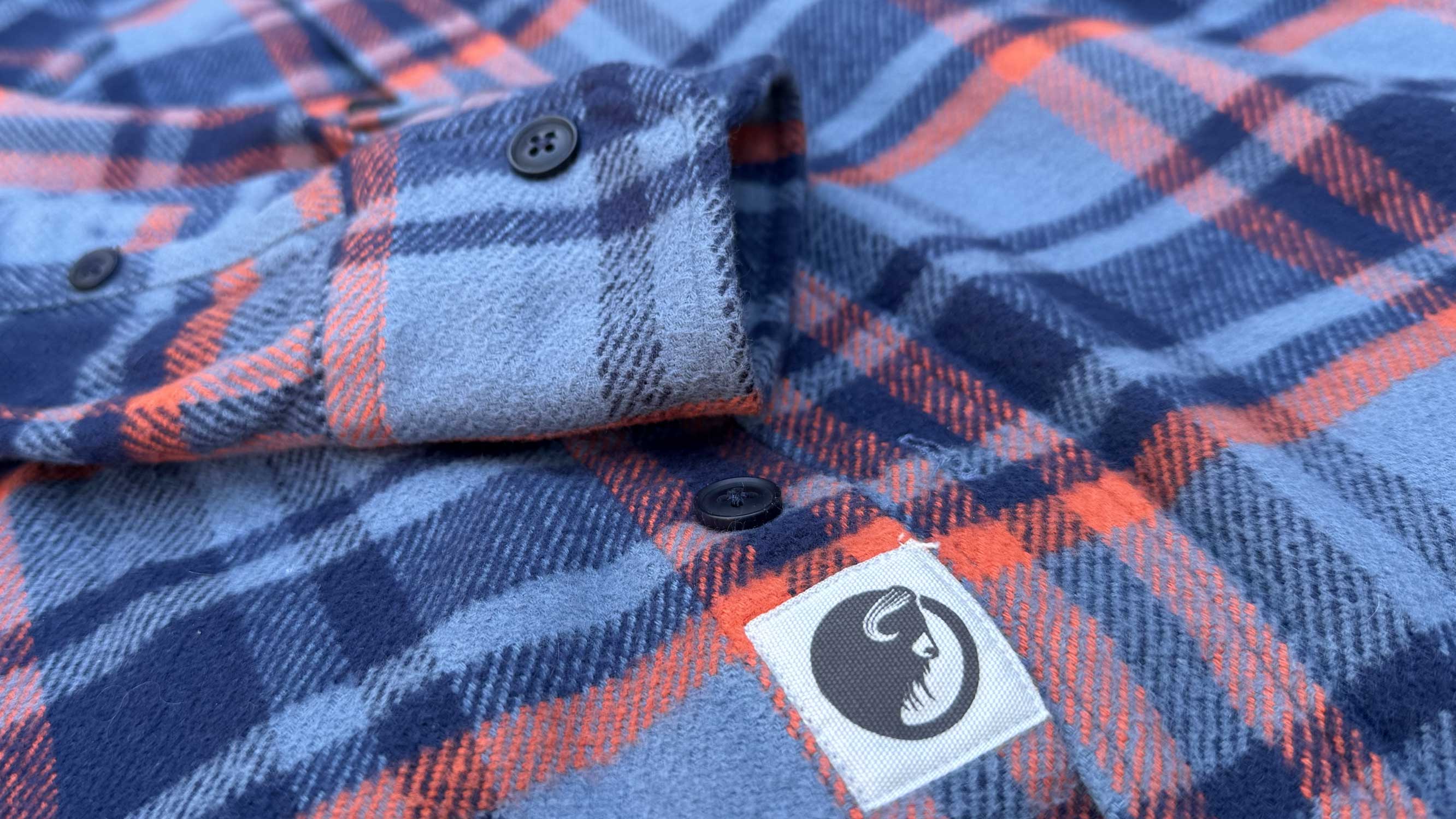 Close-up of the MuskOx logo and buttons on the flannel sleeve.