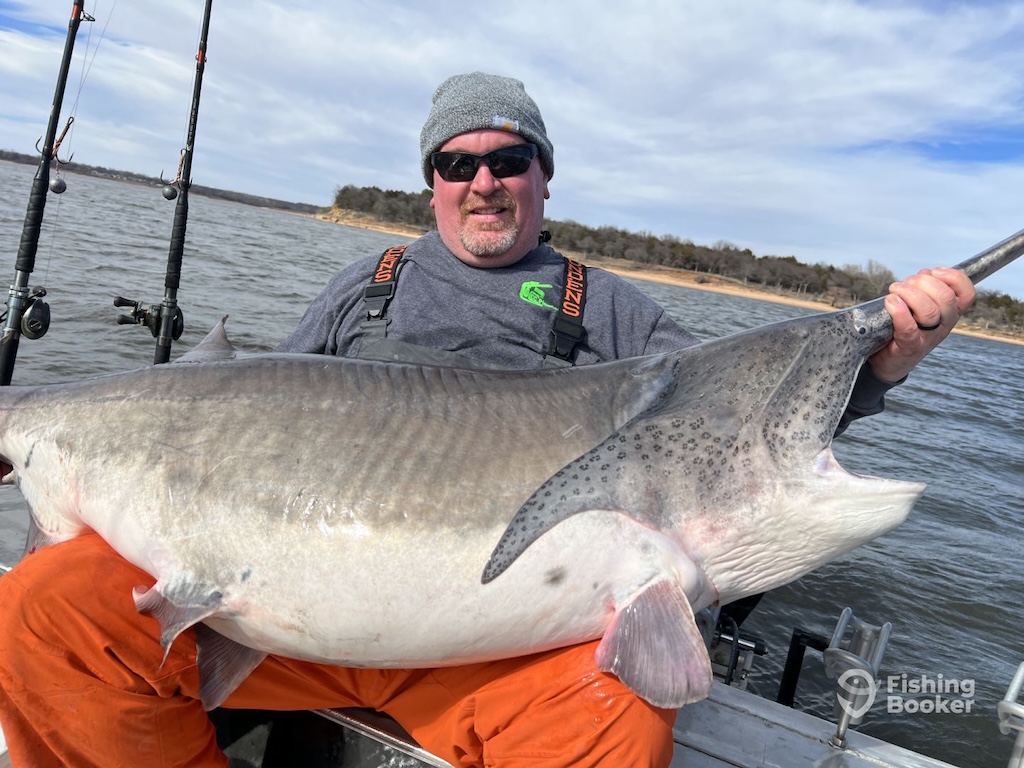 An angler preparing fishing rods on a boat.
