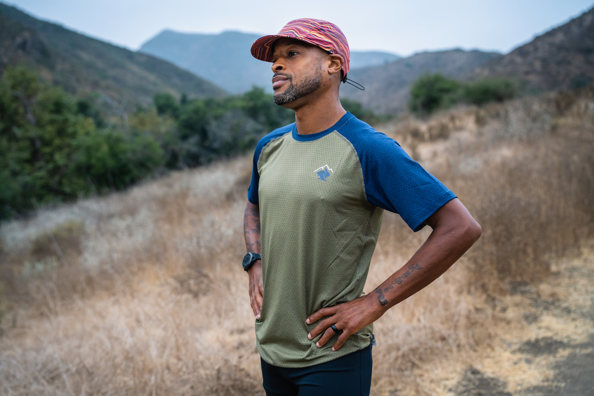 A male runner posing in the rabbit EZ Tee Perf SS on a mountain trail.