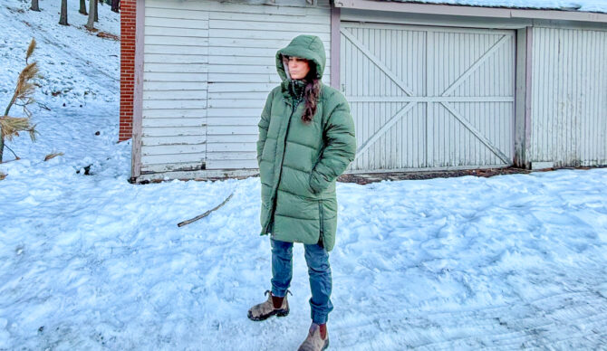 A tester wearing a brown REI Co-op Campwell Down Parka in winter weather.