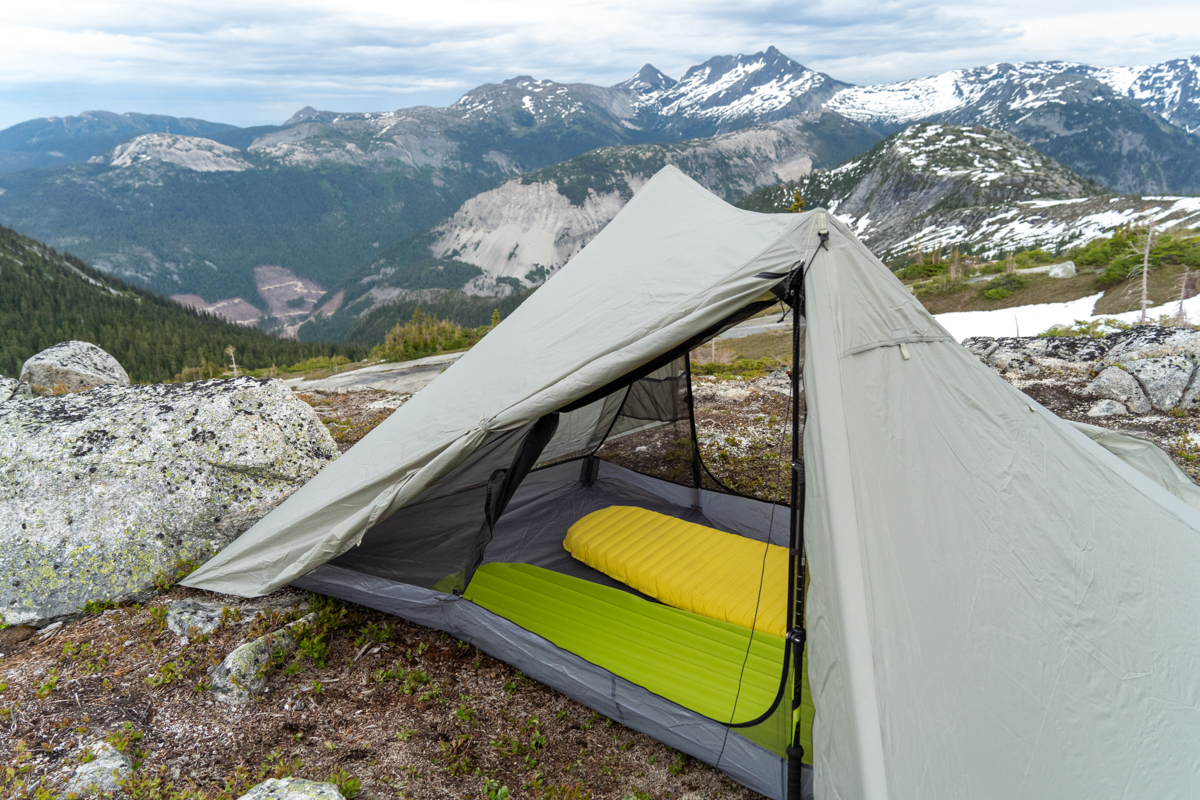 View from inside a Durston X-Mid 2 tent looking out towards a mountain ridge at sunset.