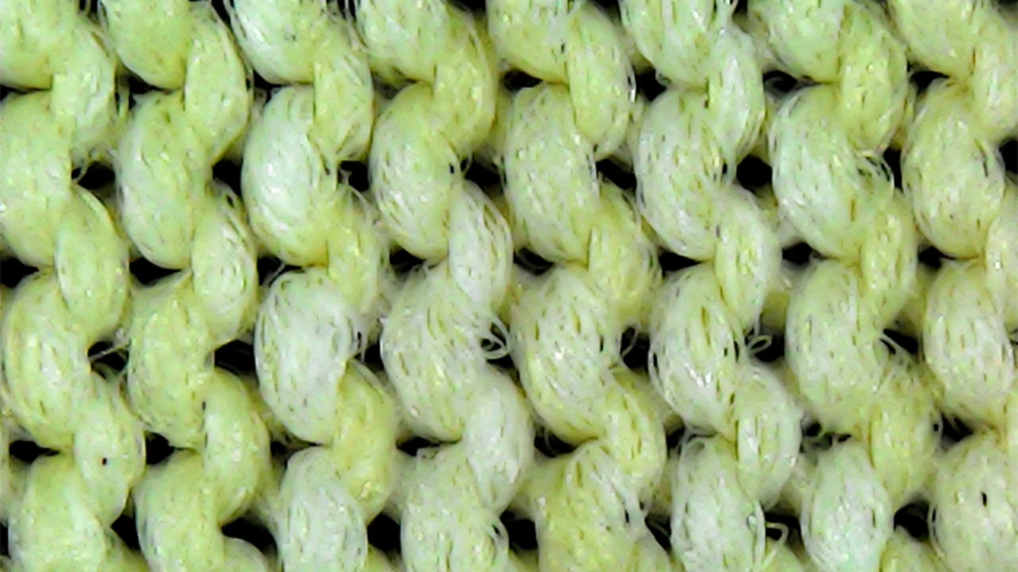 Extreme close-up of a stretchy tightly knit fabric pattern on a sun shirt.