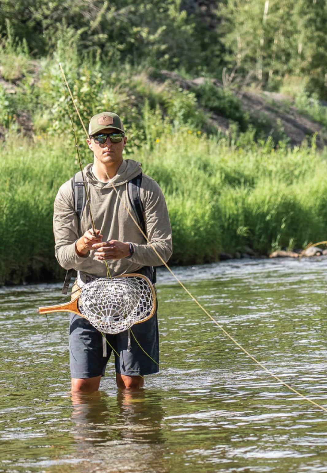 Outdoor lifestyle photo of someone wearing the ultralight River Run Hoodie in bright sunlight