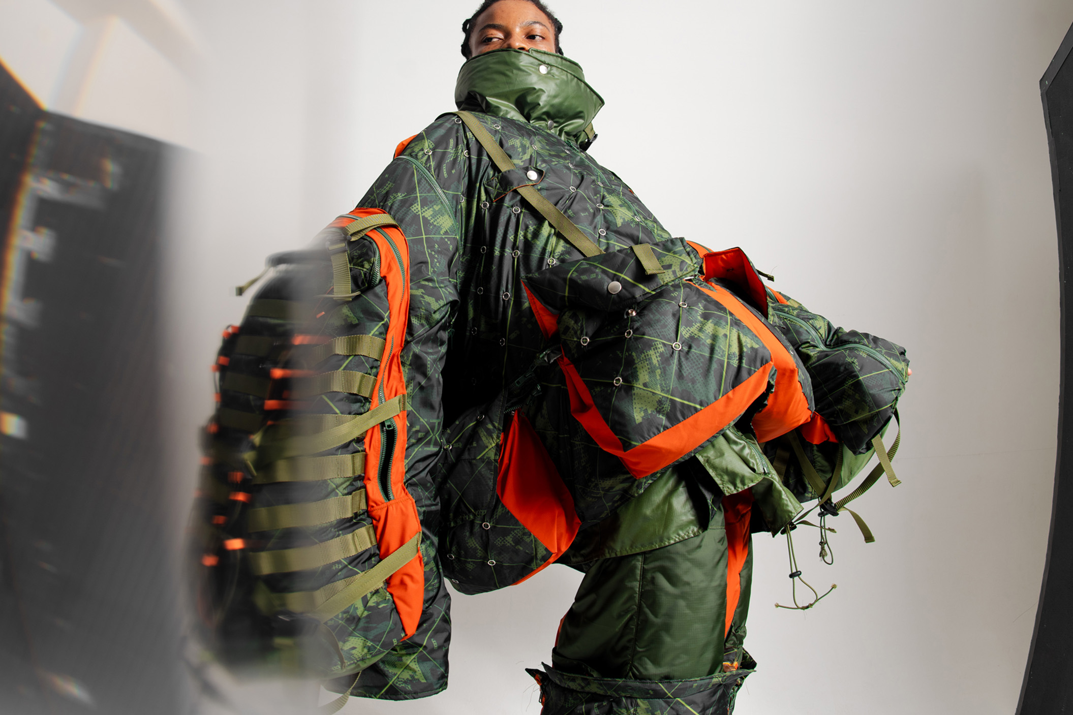 Close-up view of technical ripstop nylon and modular backpack sleeves on a shelterwear garment.