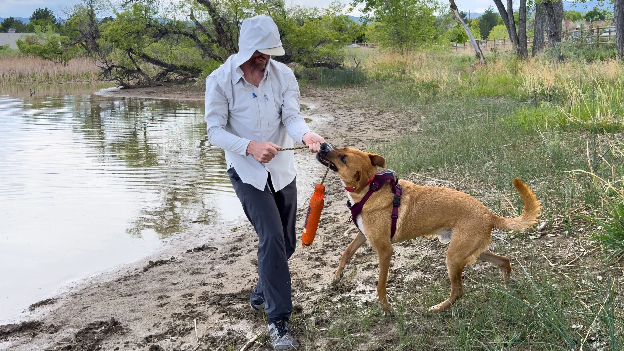 A person wearing the Patagonia River Rambler sun shirt near a lake shore.
