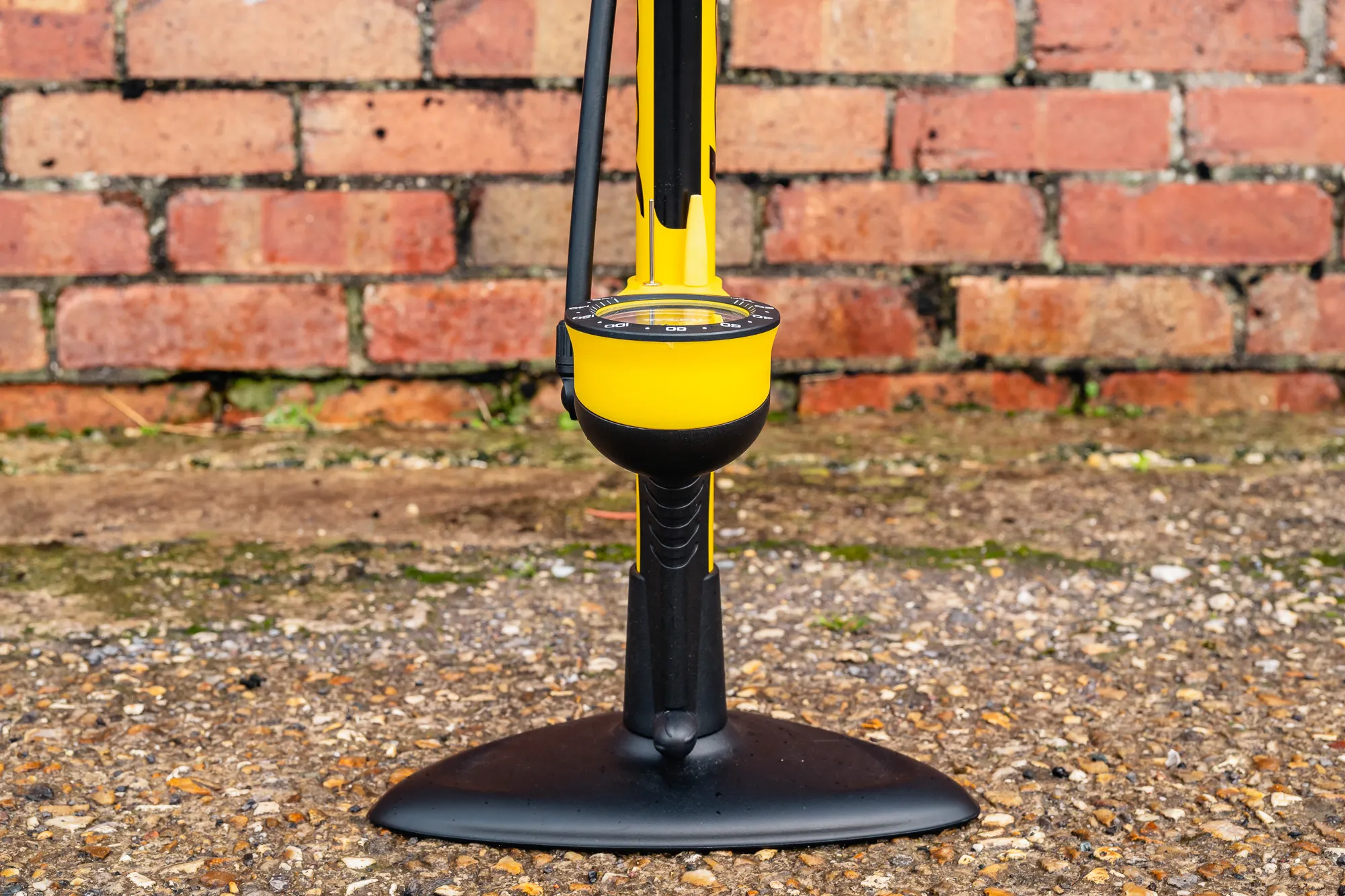 A close-up view of the wide, sturdy three-point base of a bicycle floor pump.