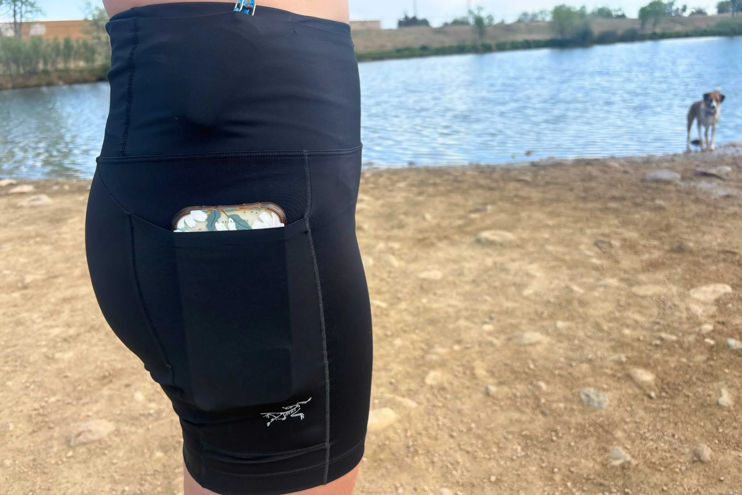 Close-up of a phone secured in the side thigh pocket of the running shorts.