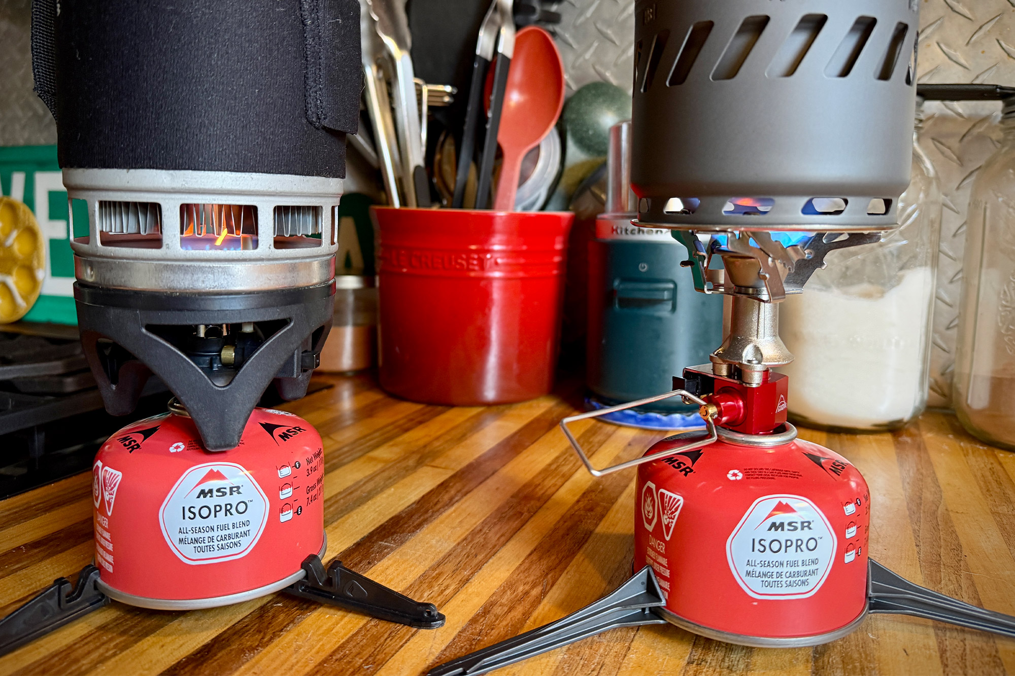 A close-up of the MSR Switch burner showing a steady blue and orange flame during an indoor test.
