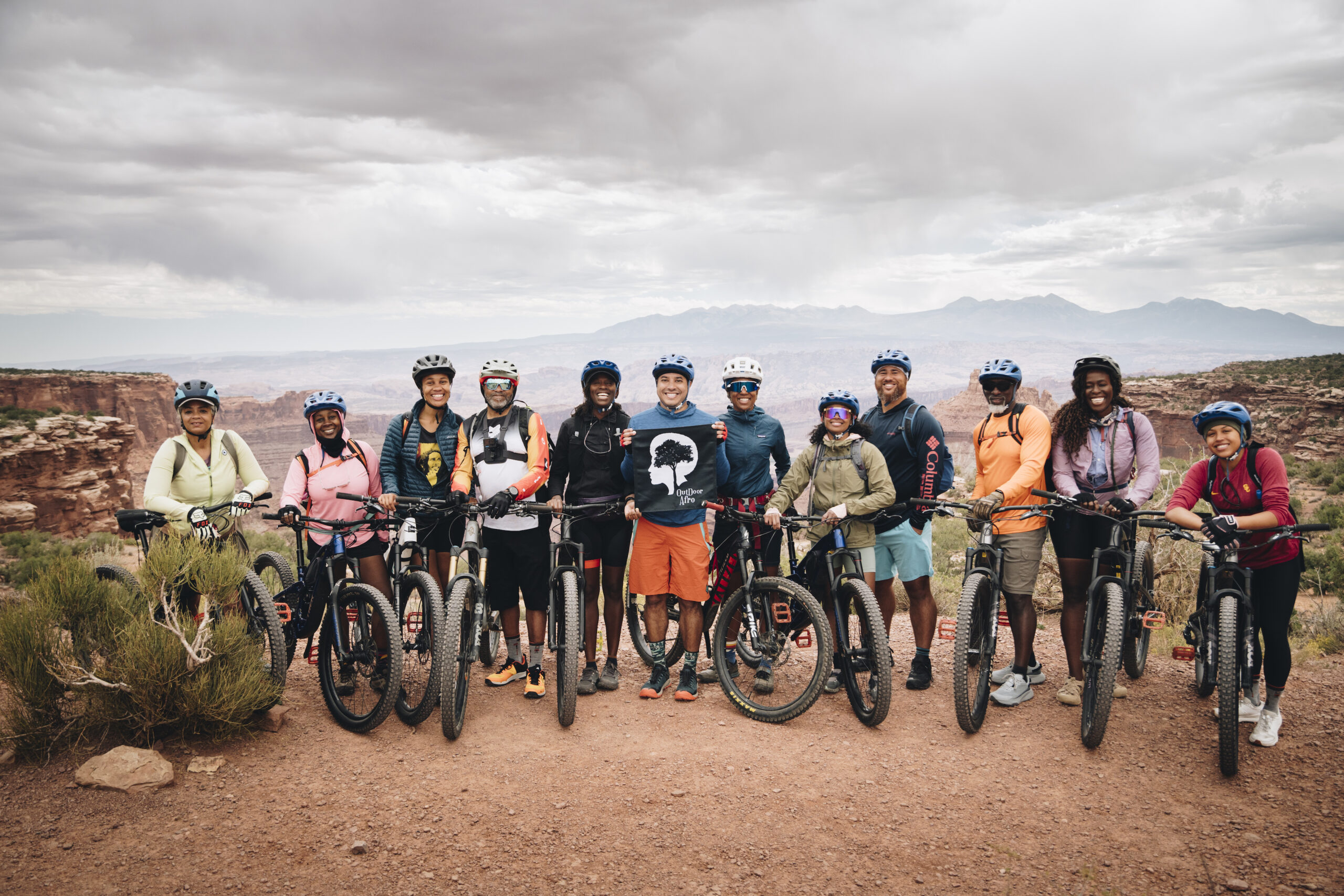 An Outdoor Afro volunteer leader riding a mountain bike on a desert trail in Moab.