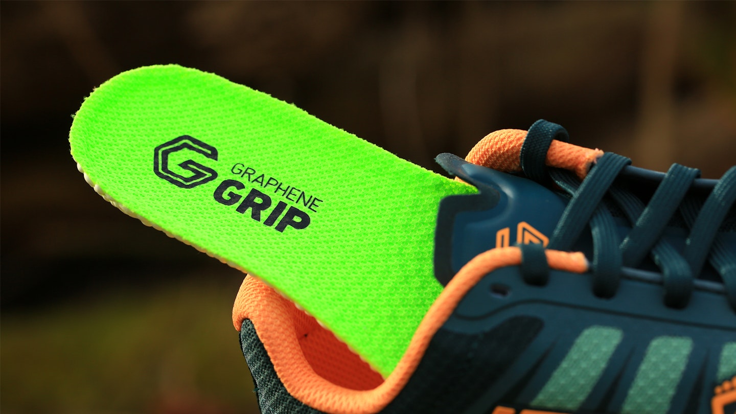 Close-up of aggressive rubber lugs on a trail running shoe outsole.