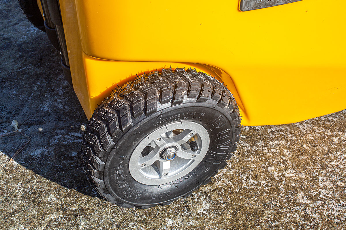 Close-up of a large, heavy-duty rubber wheel with deep treads on a RovR cooler.