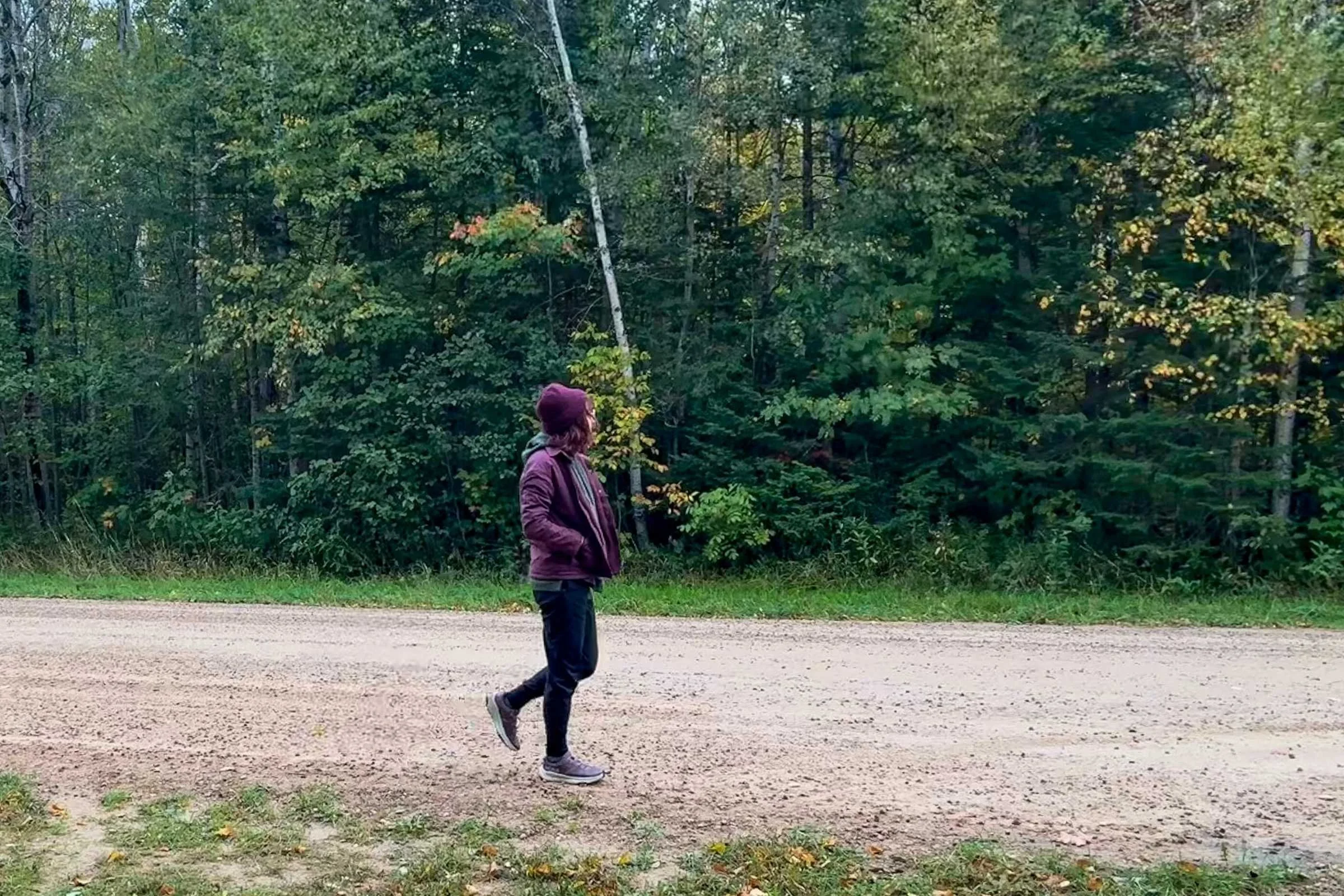 A pair of walking shoes being tested on a gravel and dirt road.