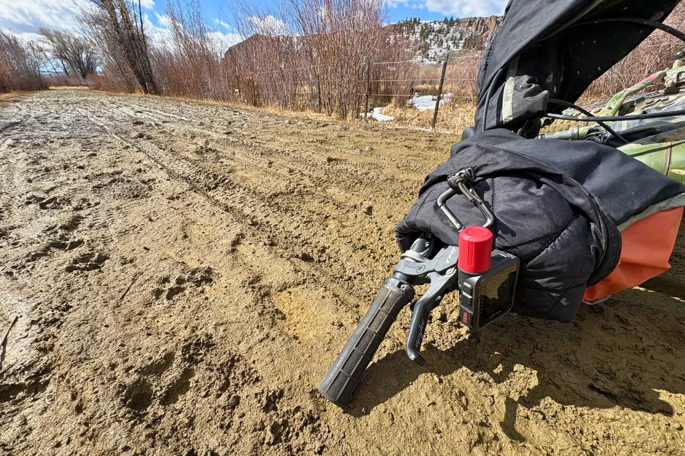 The Garmin inReach Mini 3 Plus covered in mud while attached to a bike frame.