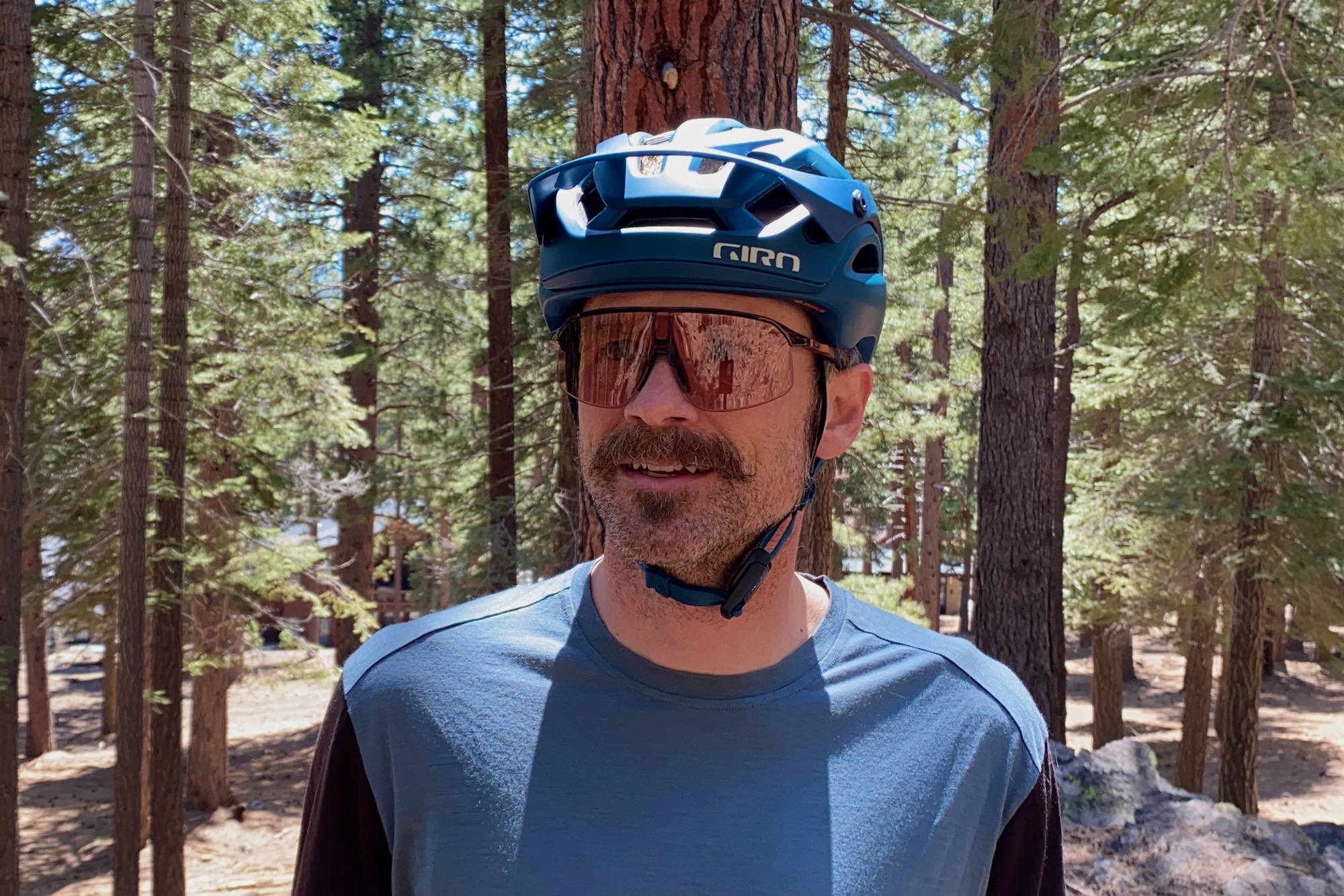 A cyclist wearing a white mountain bike helmet properly adjusted to show full temple and rear-head coverage.