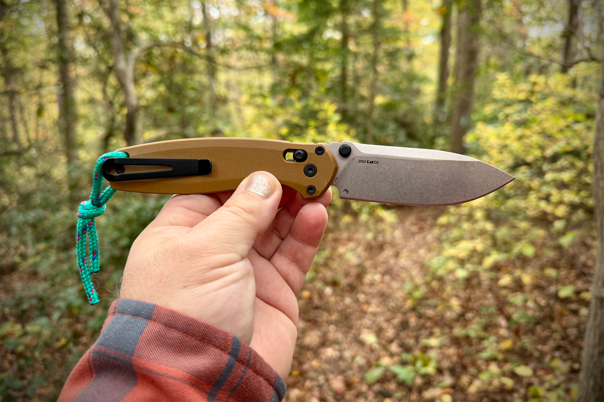A person holding the Kershaw Broadside open in their hand, showing the tan G10 handle scales and blade size.