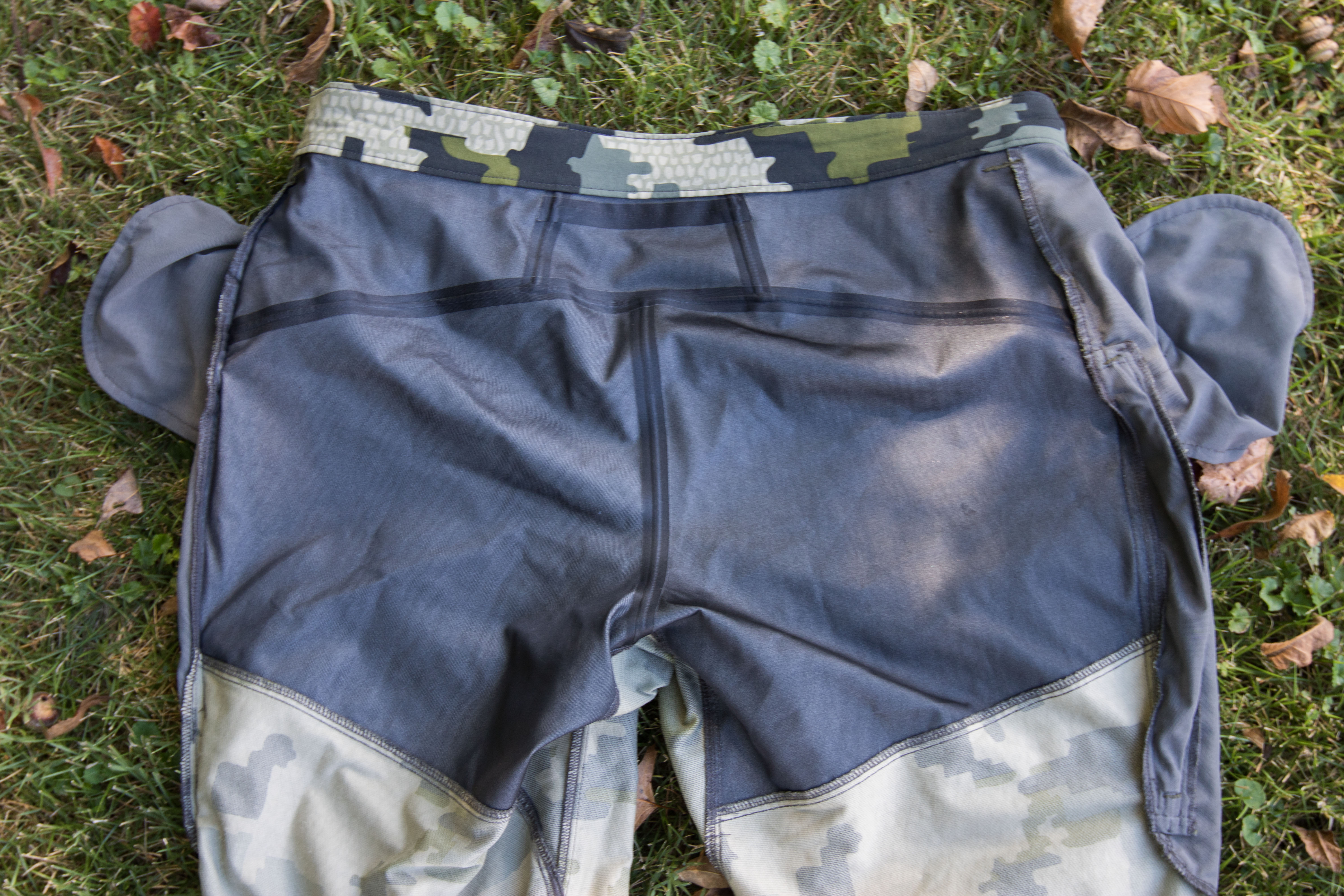 Macro view of reinforced waterproof fabric panels on the seat and knees of hunting trousers.