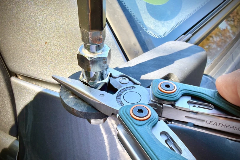 A close-up of Leatherman Wave pliers being used for a task.