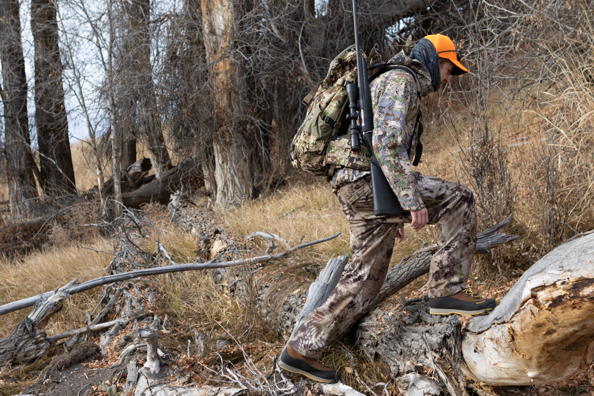 A hunter navigating deep snow and rugged terrain wearing LaCrosse hunting boots.