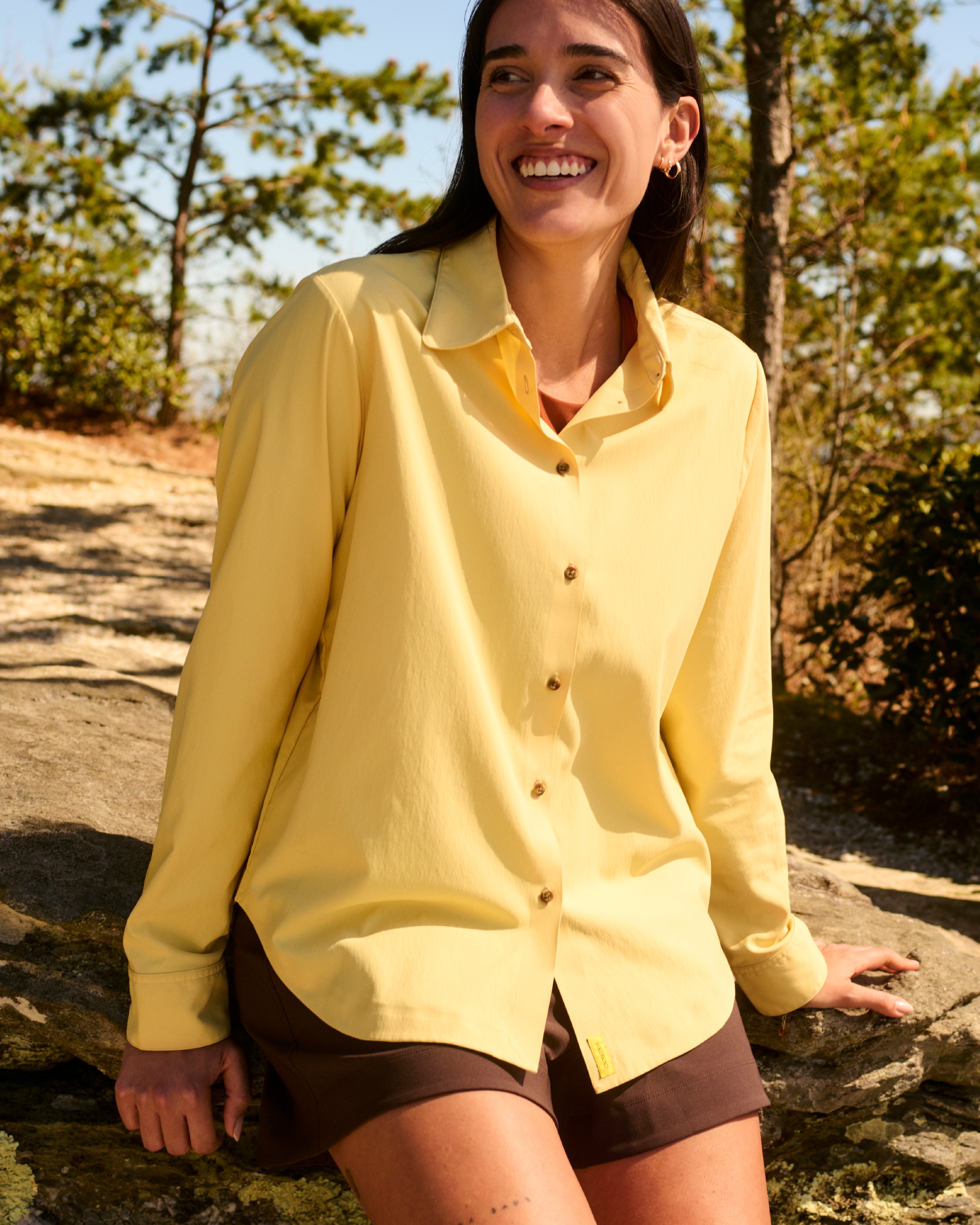 A woman wearing a breathable sun-protective hooded shirt and sunglasses while hiking.