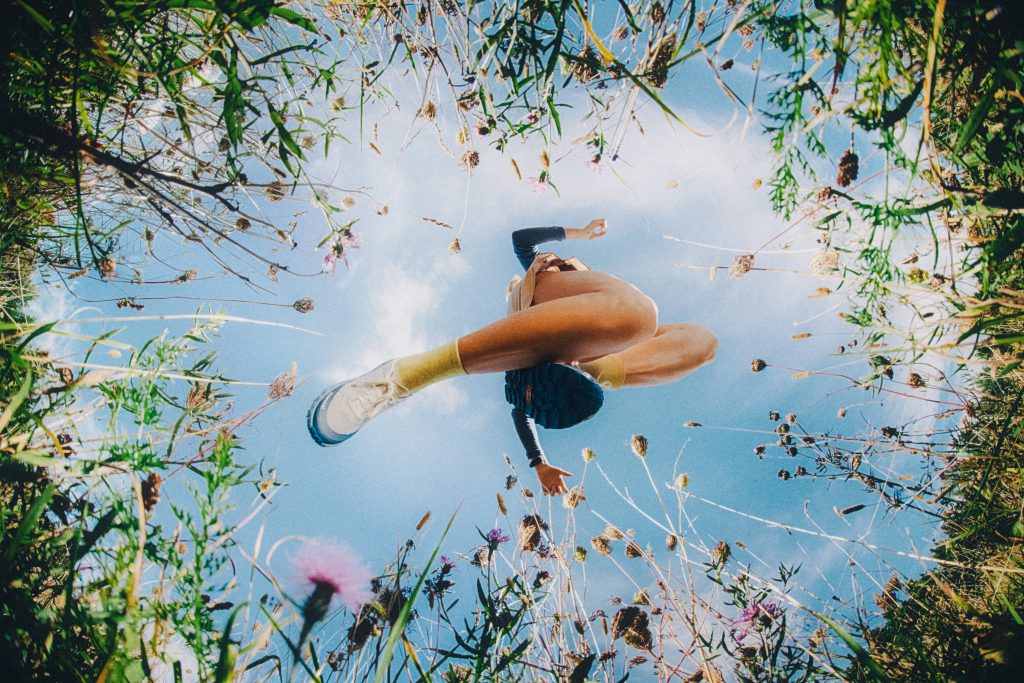 An individual jumping in Klättermusen SS2026 hiking gear in a wild landscape.