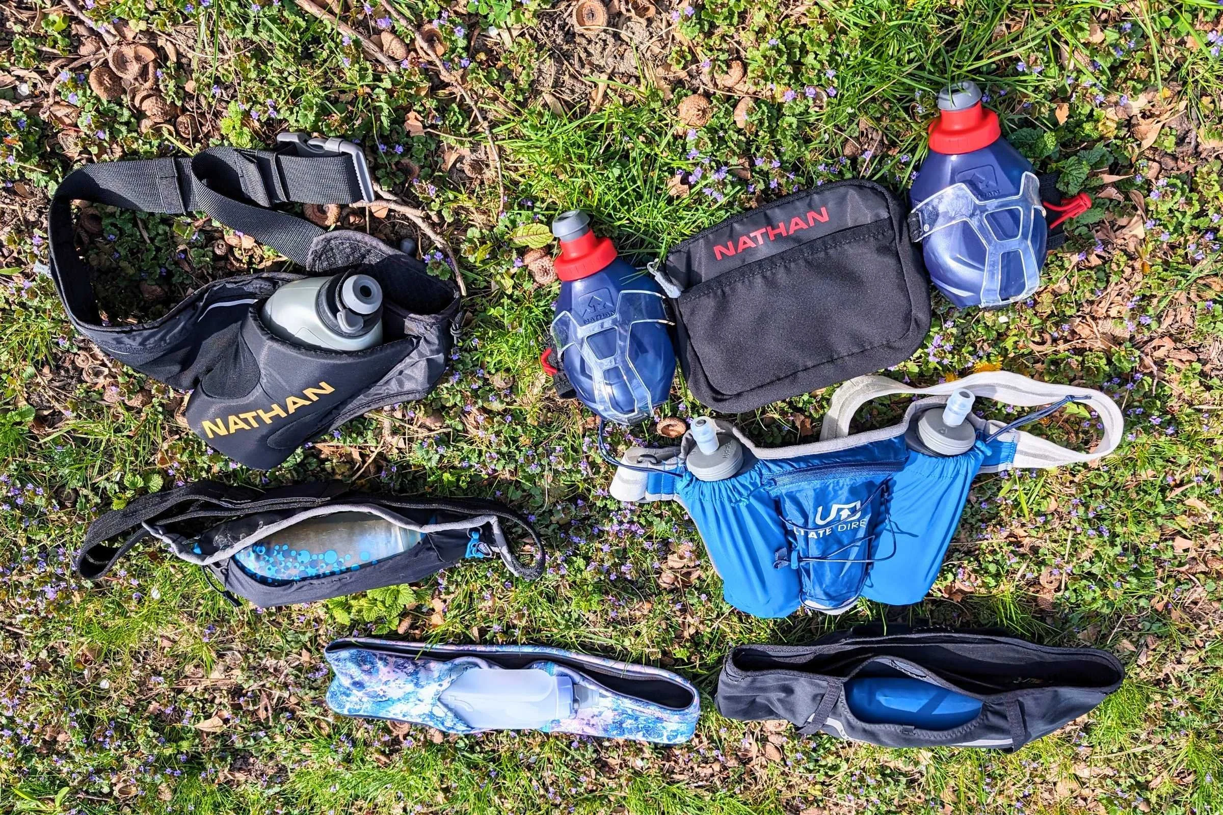 Multiple running belts displayed showing different hydration flask and bottle configurations.