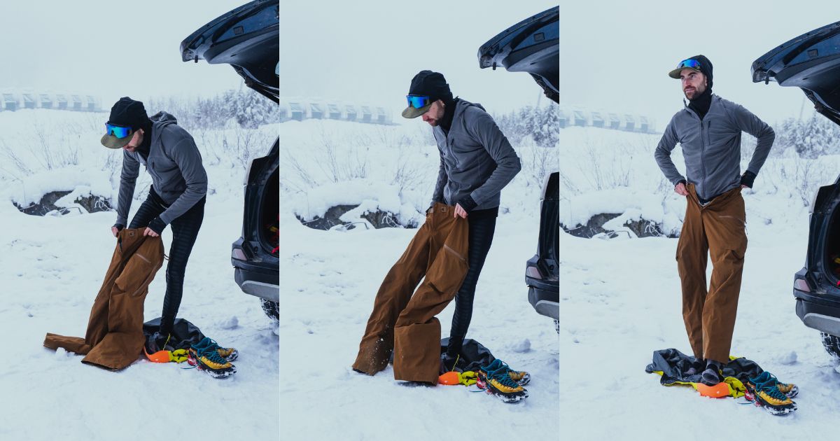 A man preparing his technical snow gear next to a vehicle in a snowy landscape.